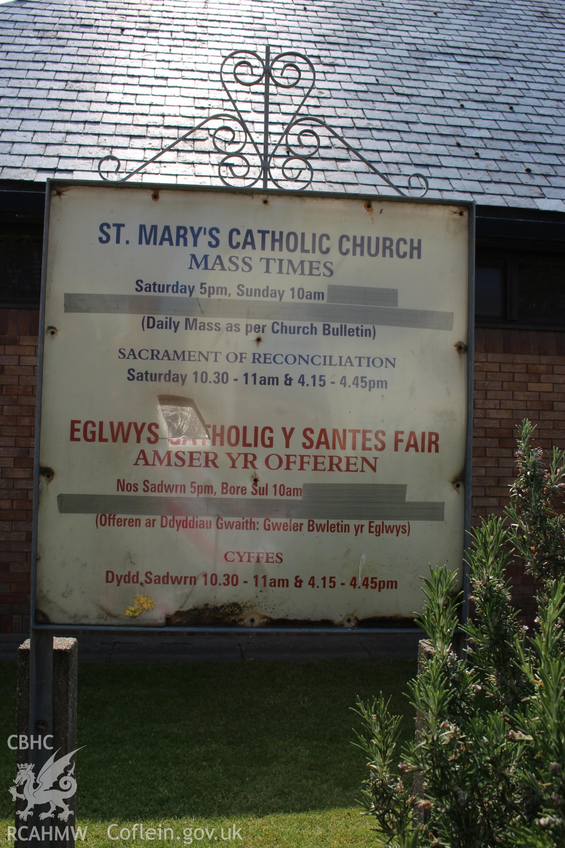 Detailed view of noticeboard showing times of worship at Our Lady of Assumption Catholic Church in Rhyl. Digital photograph taken during survey conducted by Sue Fielding for the RCAHMW, 21st January 2019.