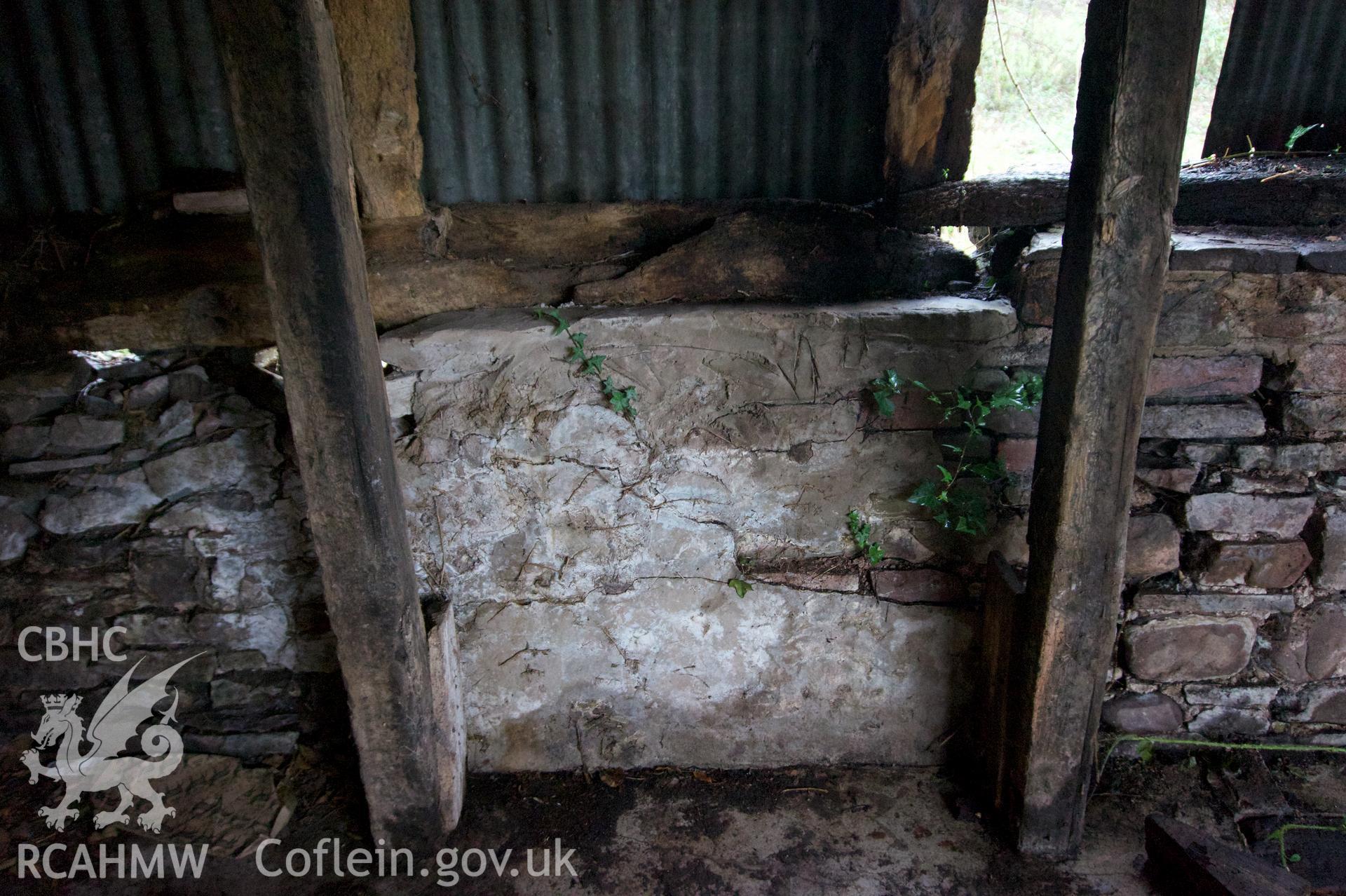 Inside of south wall plinth beneath mezzanine showing small area of render at Middle Ton Threshing Barn. Photographed for Historic Building Photographic Record of Middle Ton Threshing Barn, Llanvapley, by Dan Courtney of Cog Architects, 2019.