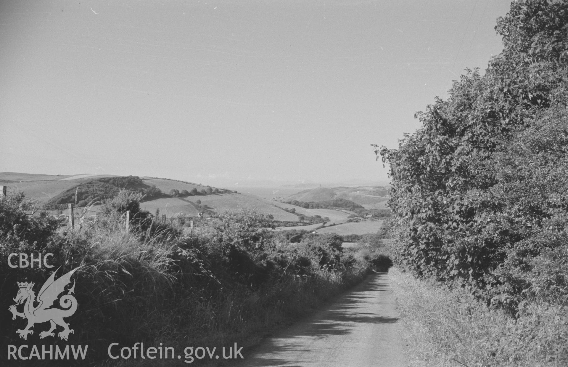 Digital copy of a black and white negative showing distant view of Pen Dinas and the coast 100m south of Troed-y-Foel. Photographed by Arthur O. Chater in August 1965 from Grid Reference SN 5868 7553, looking north.