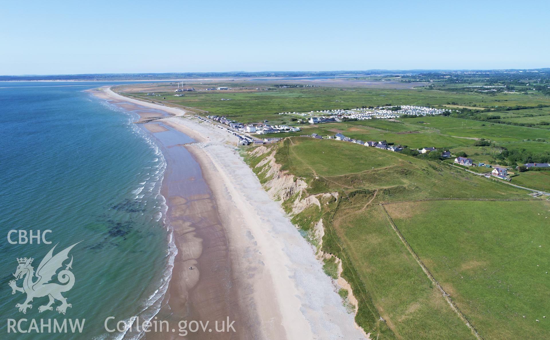 Dinas Dinlle. Low aerial view from the south using a DJI Phantom Advanced drone of the eroding cliff face, June 2018, looking north to Dinas Dinlle village and Morfa Dinlle (CH2019_183), for the CHERISH Project.
