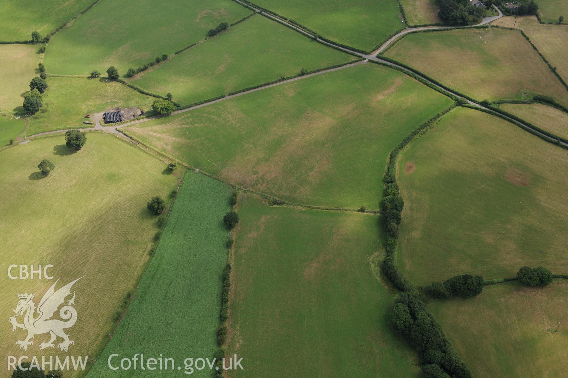 Cropmarks of Roman camp west of Caerau Roman fort and possible square ditched barrow, Beulah, west of Builth Wells. Oblique aerial photograph taken during the Royal Commission?s programme of archaeological aerial reconnaissance by Toby Driver on 1st August 2013.