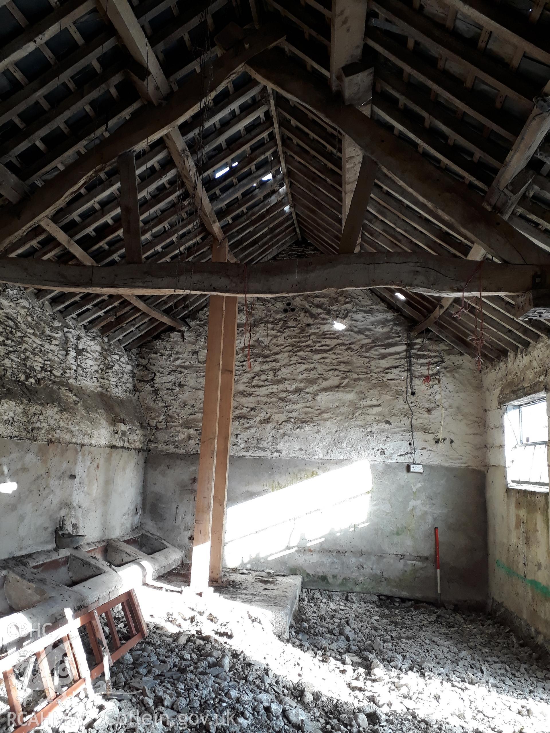 Barn interior with roof truss, view north east. 1m scale. Photographed as part of archaeological building recording conducted at Bryn Ysguboriau, Llanelidan, Denbighshire, carried out by Archaeology Wales, 2018. Project no. P2587.