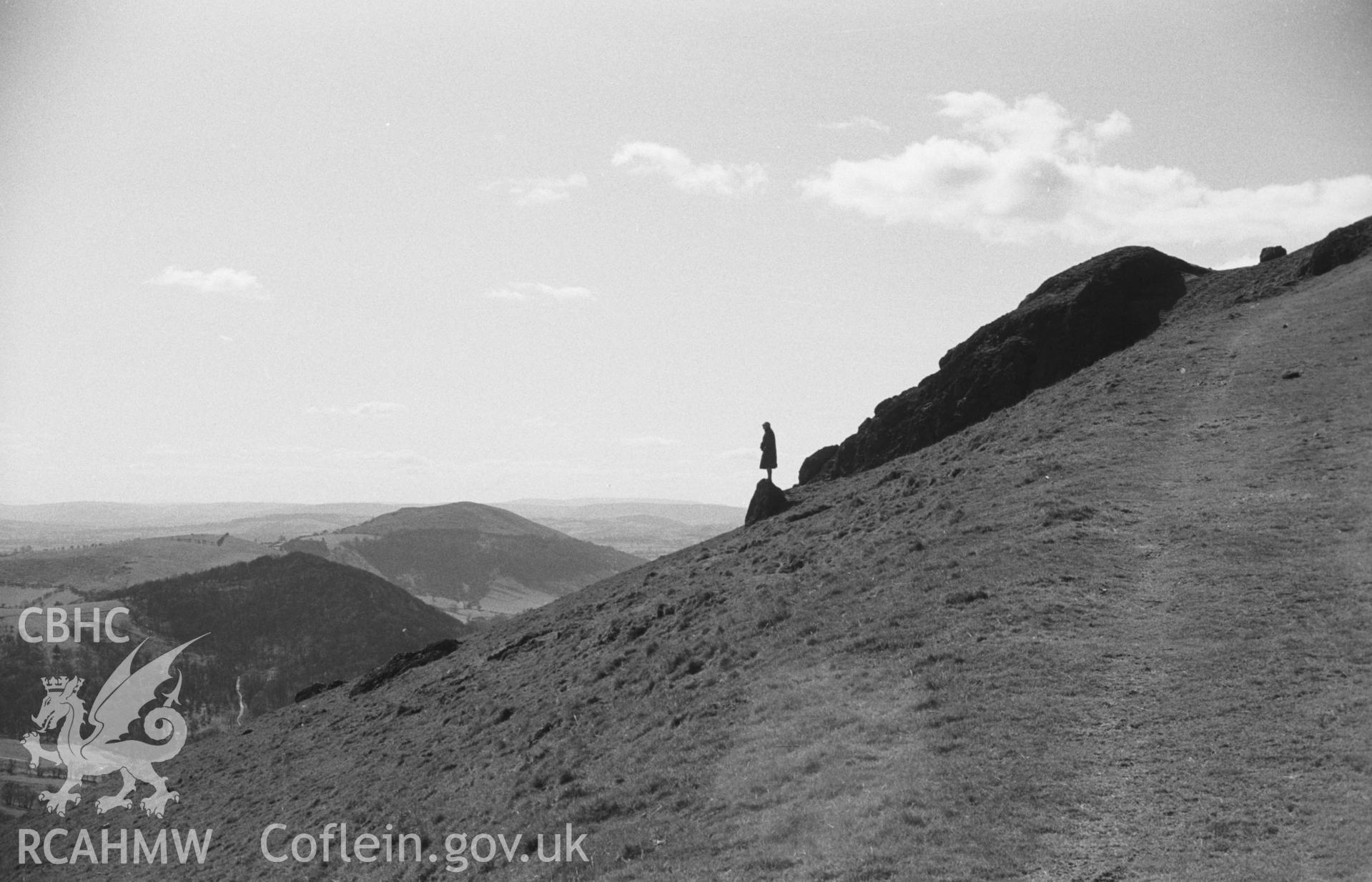 Digital copy of a black and white negative showing Caer Caradog, Shropshire, with figure in silhouette. Photographed in March 1964 by Arthur O. Chater.