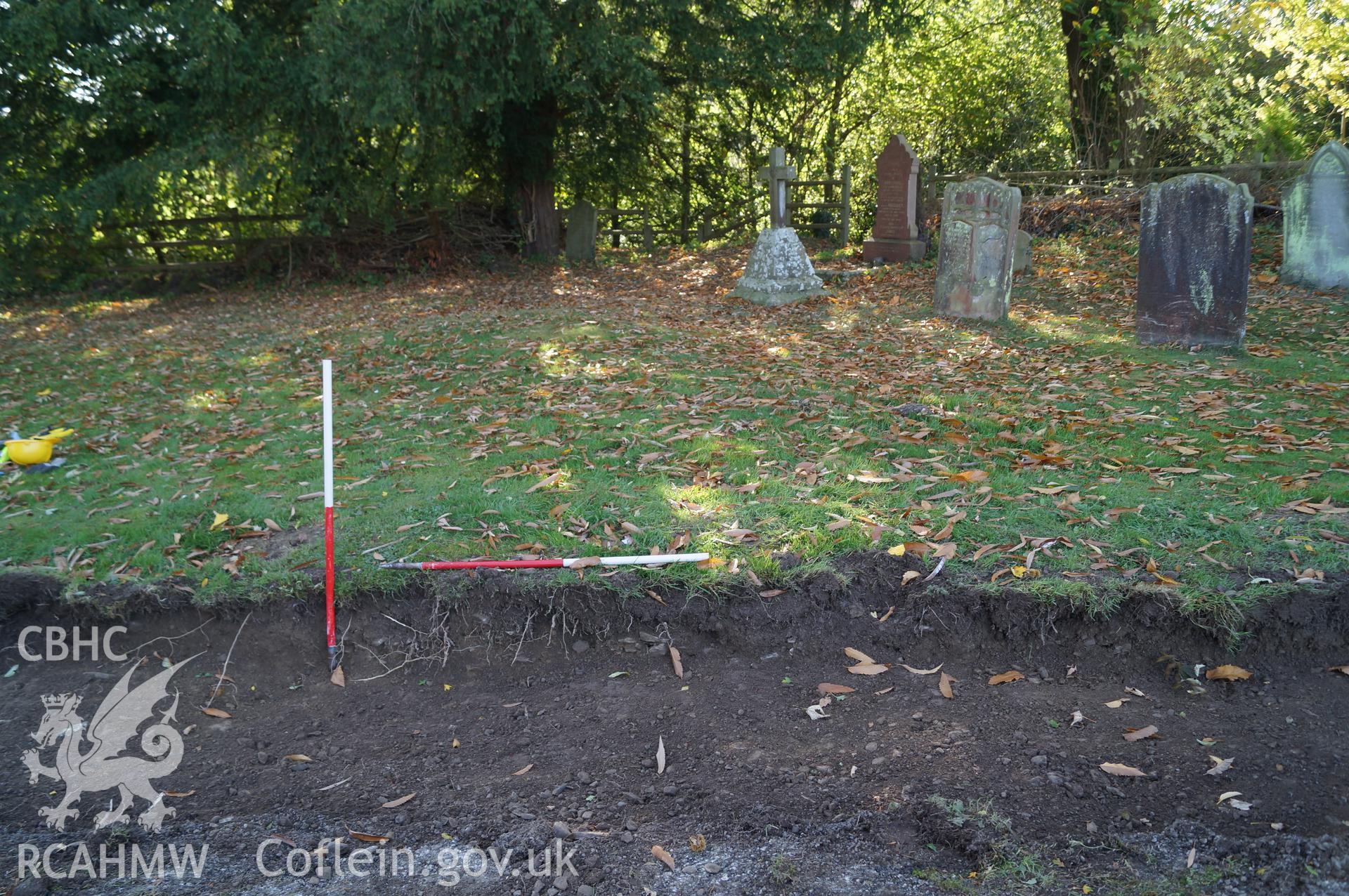 View 'looking south southwest at stone band and clay band in Trench B which appear to relate to irregular linear mound in southern side of graveyard' at St. Mary's, Gladestry. Photograph & description by Jenny Hall & Paul Sambrook of Trysor, 16/10/2017.