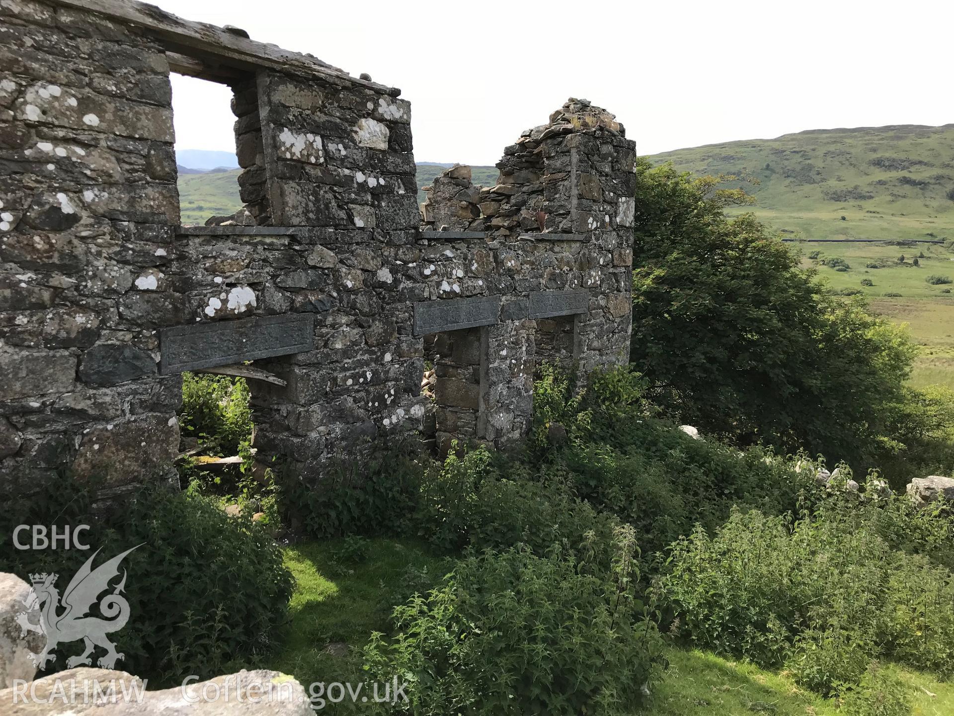 Colour photo showing external view of the remains of one of Brwynog Isaf farmhouse's walls, taken by Paul R. Davis, 23rd June 2018.