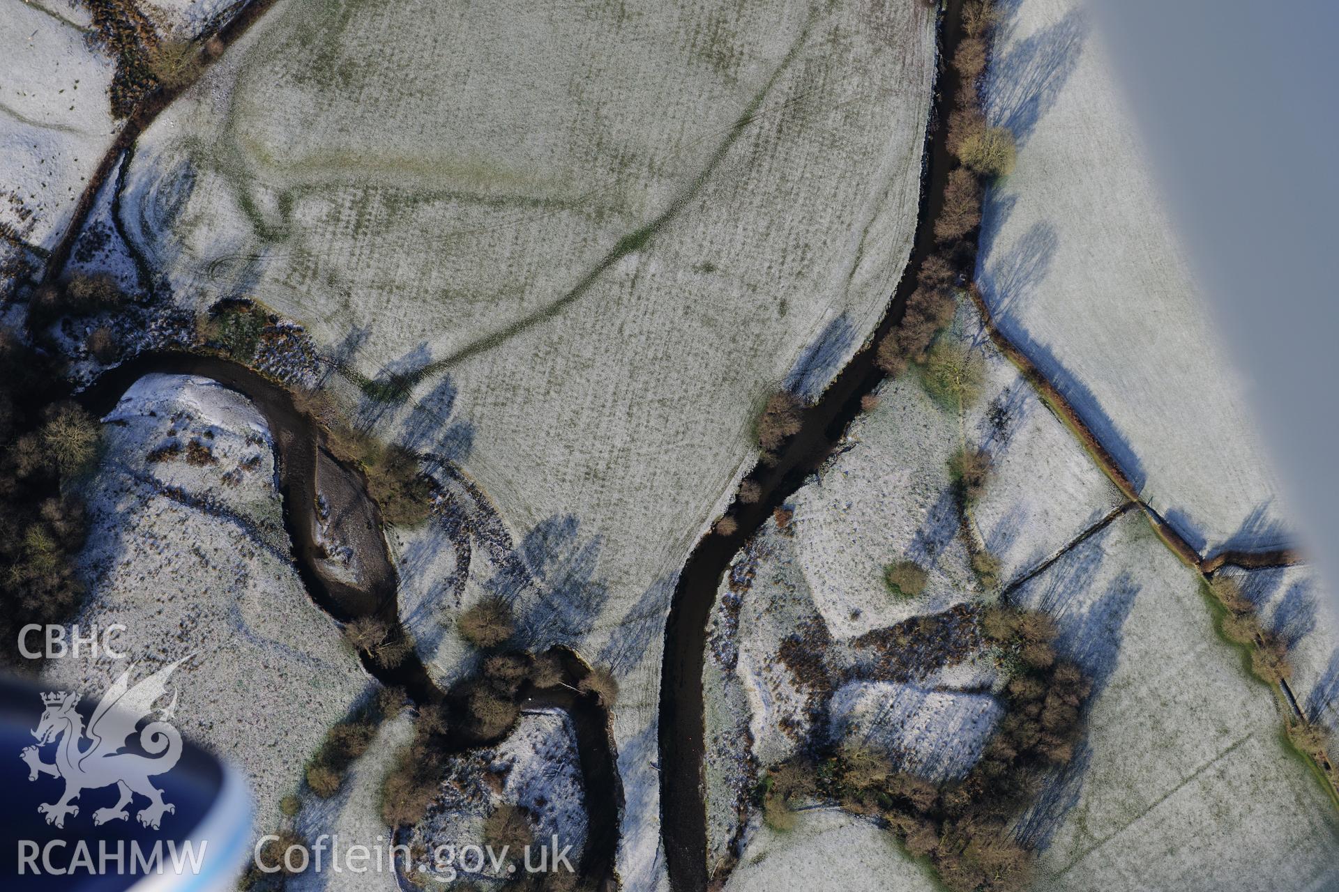 Riverside earthworks to the south-east of Caerau Roman Fort, Beulah, west of Builth Wells. Oblique aerial photograph taken during the Royal Commission?s programme of archaeological aerial reconnaissance by Toby Driver on 15th January 2013.