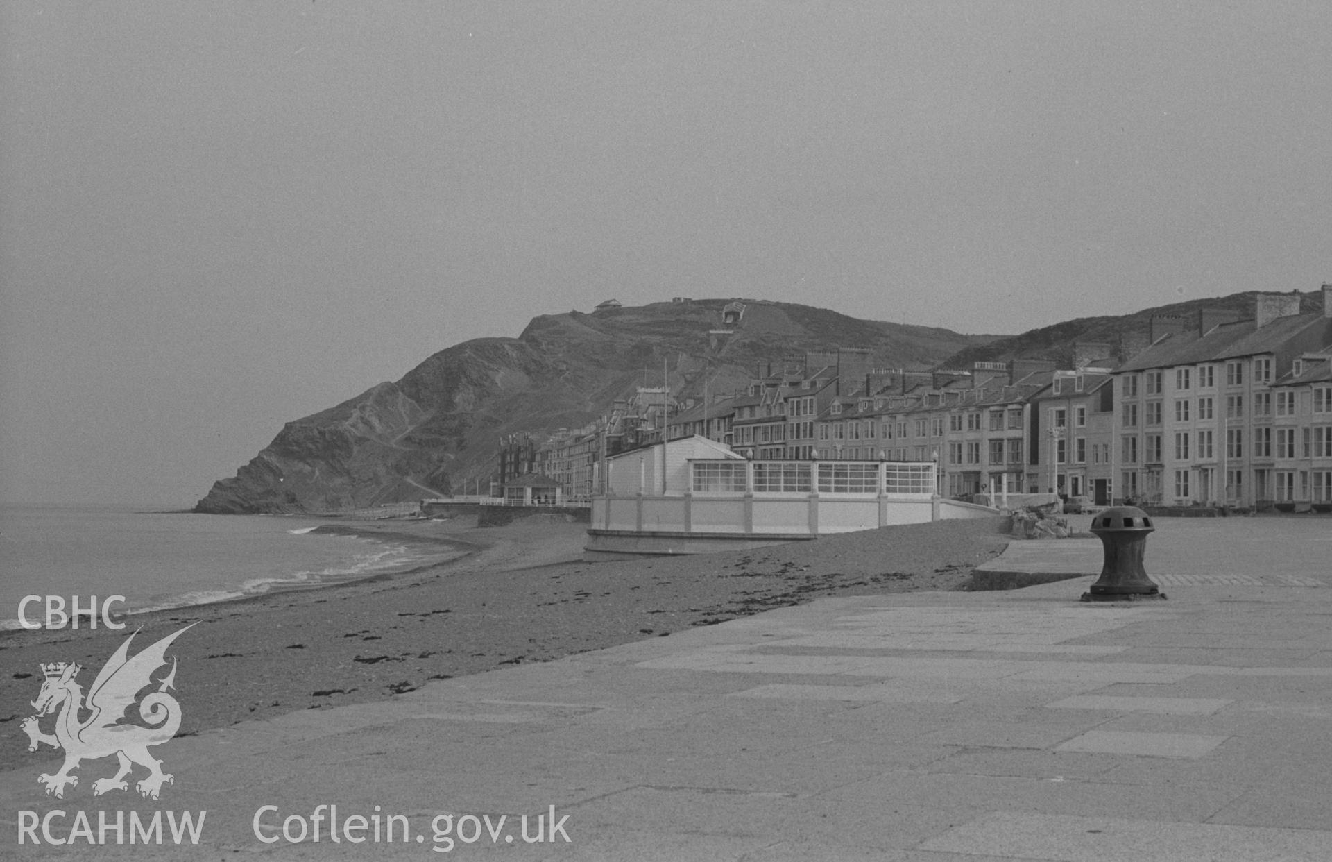 Digital copy of a black and white negative showing the promenade, grandstand and Constitution Hill with capstan in the foreground. Photographed by Arthur O. Chater on 13th April 1967 looking north from Grid Reference SN 583 818.