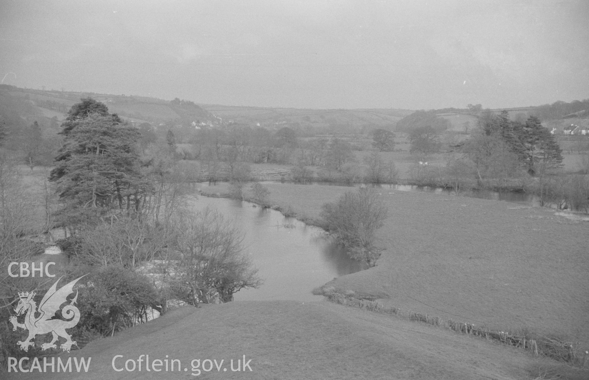 Digital copy of black & white negative showing view from the eastern end of the castle earthworks across the Teifi and up the valley with Llandyfriog in the distance. Photograph by Arthur O. Chater, April 1966, looking east north east from SN 312 407.