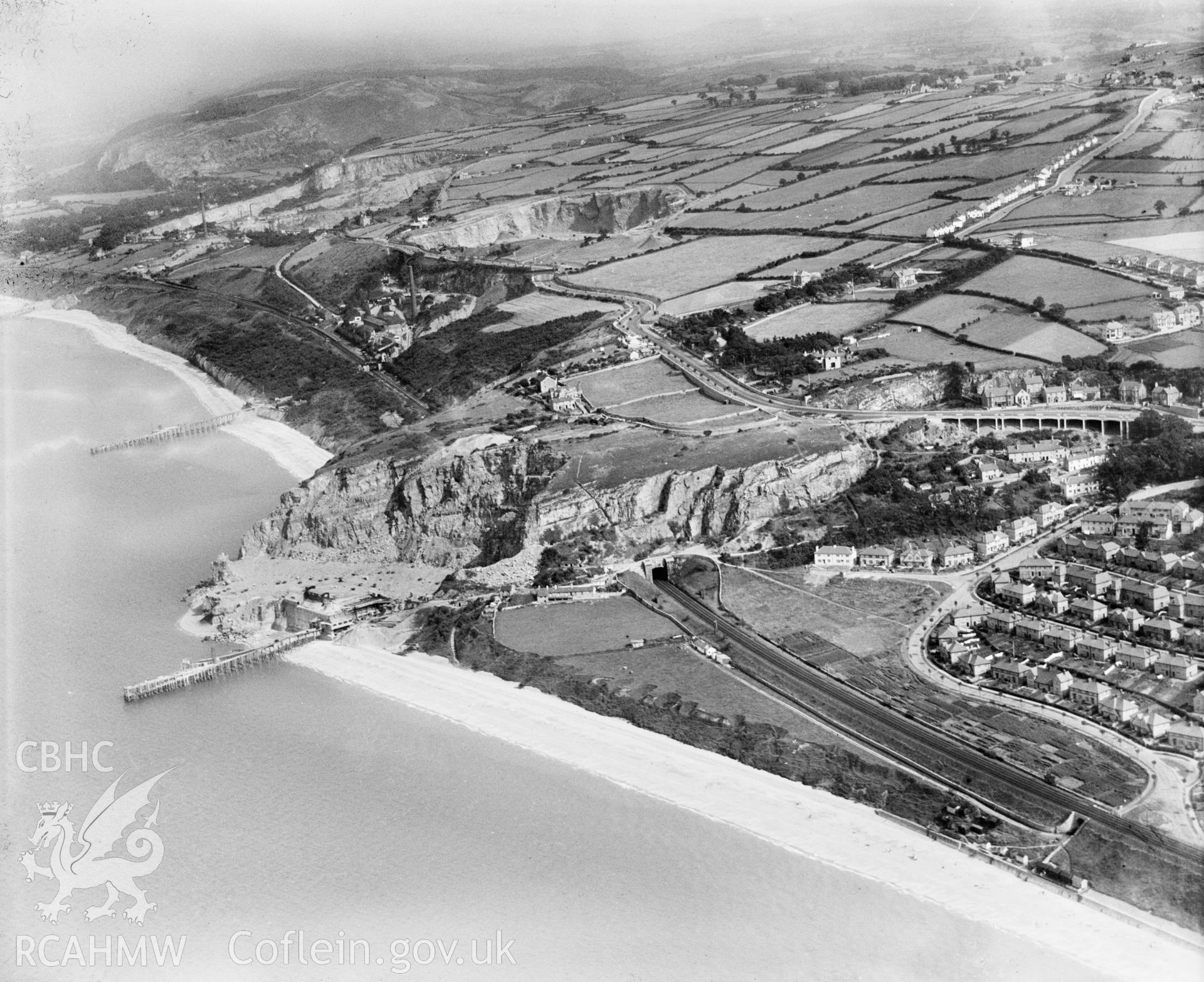 View of Penmaen Quarry, Old Colwyn, showing railway tunnel, oblique aerial view. 5?x4? black and white glass plate negative.