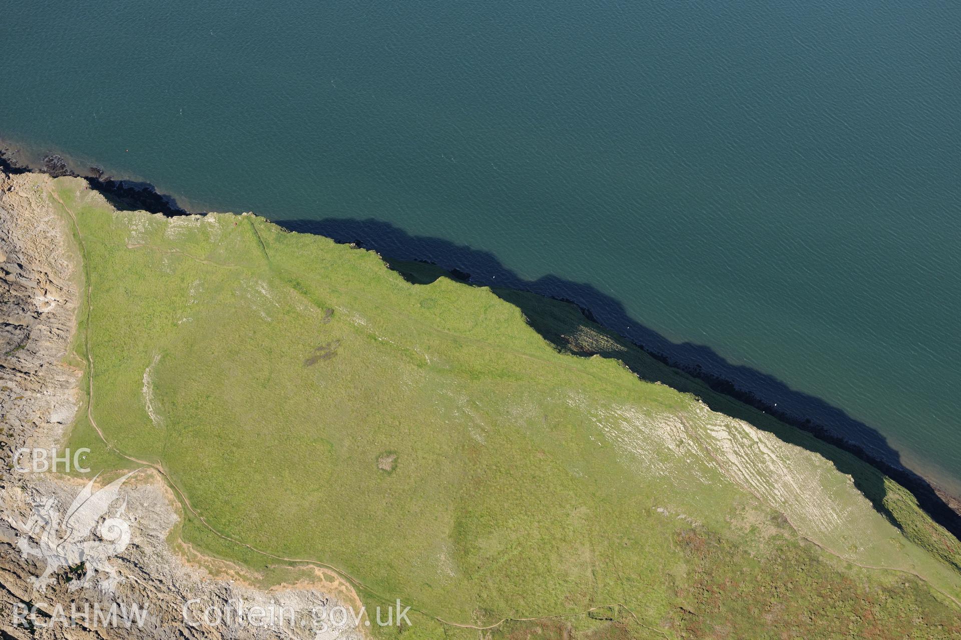 Worm's Head and the enclosure on its north eastern side, near Rhossili, on the western coast of the Gower Peninsula. Oblique aerial photograph taken during the Royal Commission's programme of archaeological aerial reconnaissance by Toby Driver on 30th September 2015.