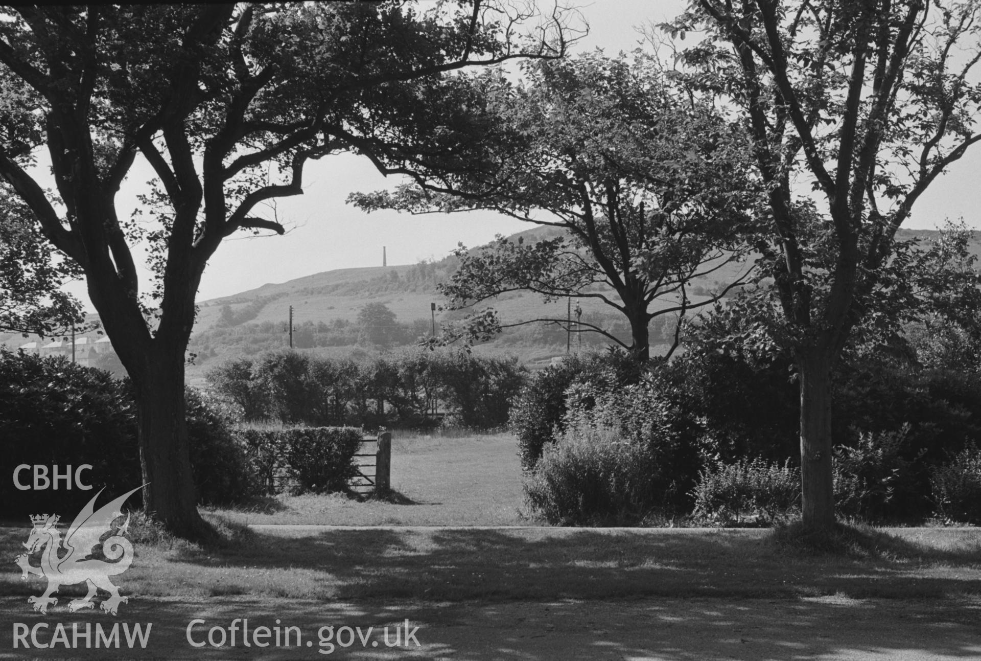 Digital copy of a black and white negative showing Plascrug Avenue with the Wellington Monument on Pen Dinas beyond, Aberystwyth. Photographed by Arthur O. Chater in August 1967. (Looking south south west from Grid Reference SN 588 813).