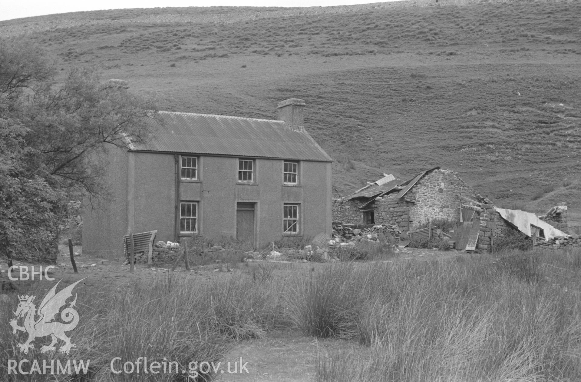 Digital copy of a black and white negative showing Moel Prysgau farmstead, on the banks of the Tywi river south east of Pontrhydfendigaid. Photographed by Arthur O. Chater in August 1965 from Grid Reference SN 8062 6110, looking north west.