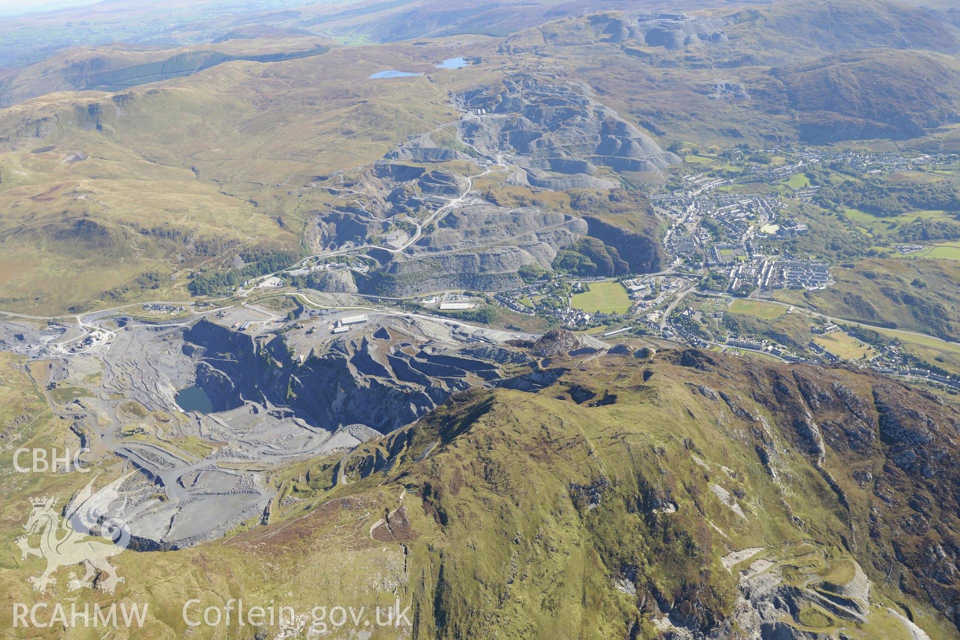 Oakley & Llechwedd slate quarries with Blaenau Ffestiniog & Blaenau Ffestingiog rugby football ground below. Oblique aerial photograph taken during the Royal Commission's programme of archaeological aerial reconnaissance by Toby Driver on 2nd October 2015.