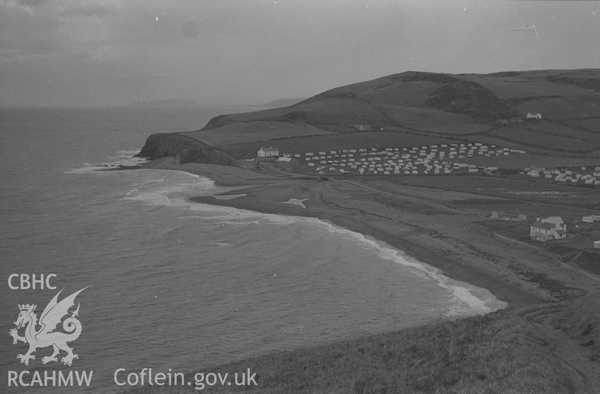 Digital copy of a black and white negative showing Clarach Bay with caravans. Photographed by Arthur O. Chater on 25th December 1964 from the cliff path at Grid Reference SN 5865 8346, looking north.