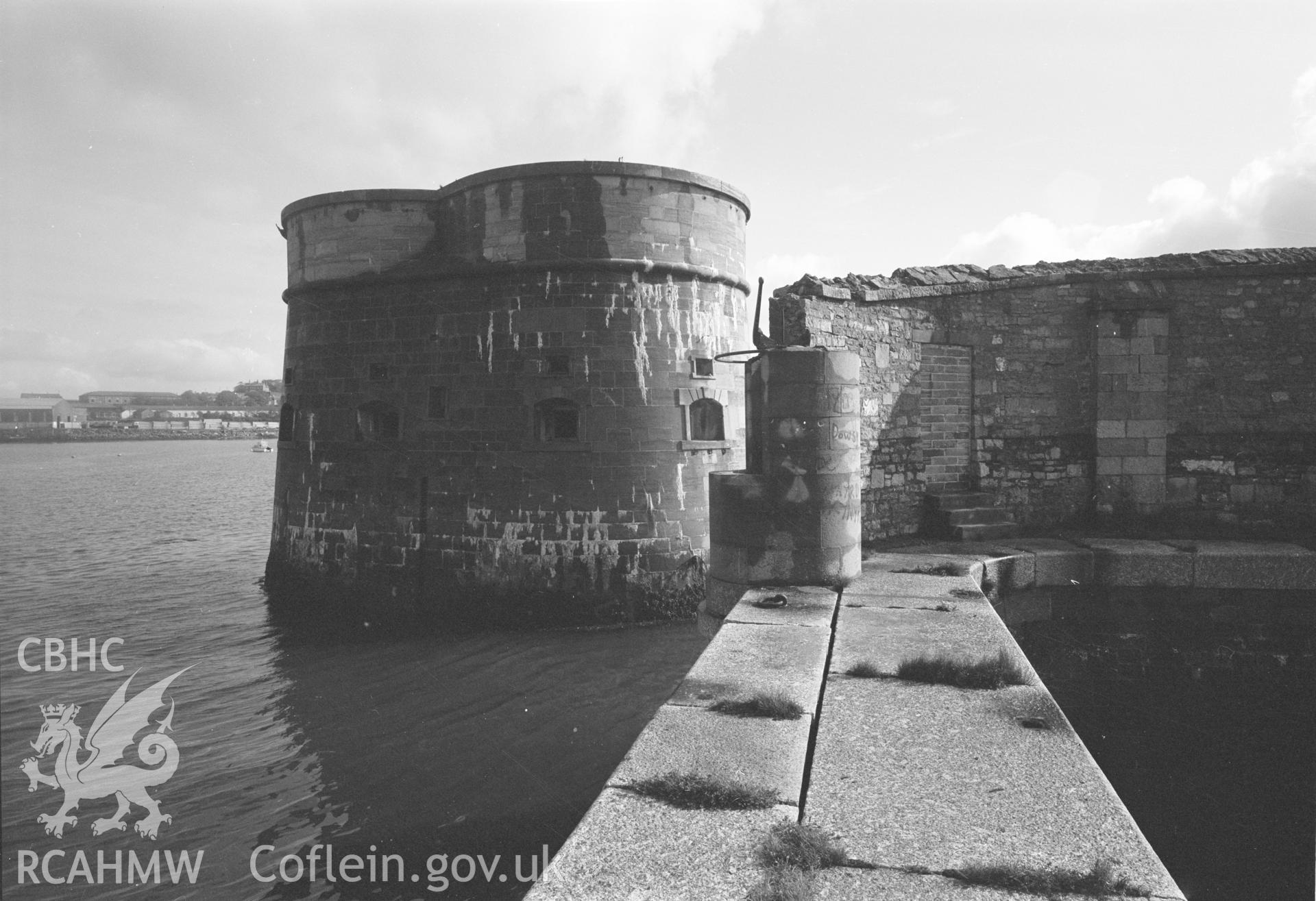 Digital copy of a black and white negative showing Old Royal Dockyard Pembroke - NE inside corner of Dockyard Wall  boat slip & NE Martello Tower looking E taken by RCAHMW.