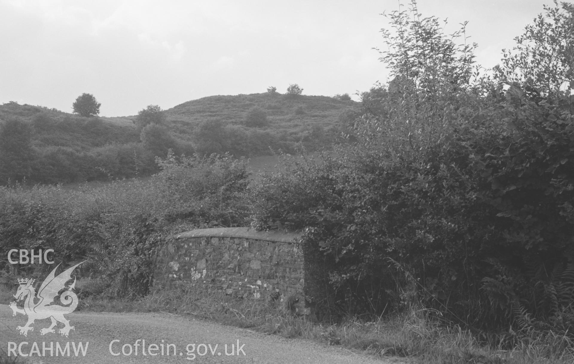 Digital copy of a black and white negative showing iron age camp Gaer, Troedyrhiw, Llandysul (and road bridge). Photographed by Arthur O. Chater on 19th August 1967 looking west north west from Grid Reference SN 392 459.