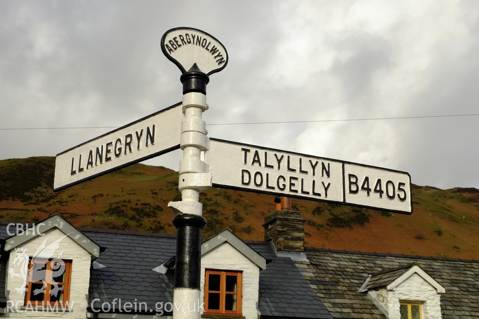 Colour photograph showing view from the south looking at the road sign in Abergynolwyn at the junction of the main road with Heol Llanegryn, produced by Richard Hayman 7th February 2017