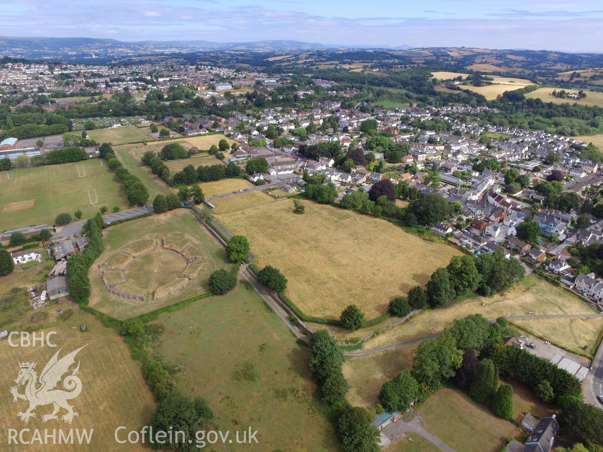 Colour photograph showing the remains of Isca Leginary Fortress including the Roman amphitheatre, with views of Caerleon town beyond. Taken by Paul R. Davis on 22nd July 2018.