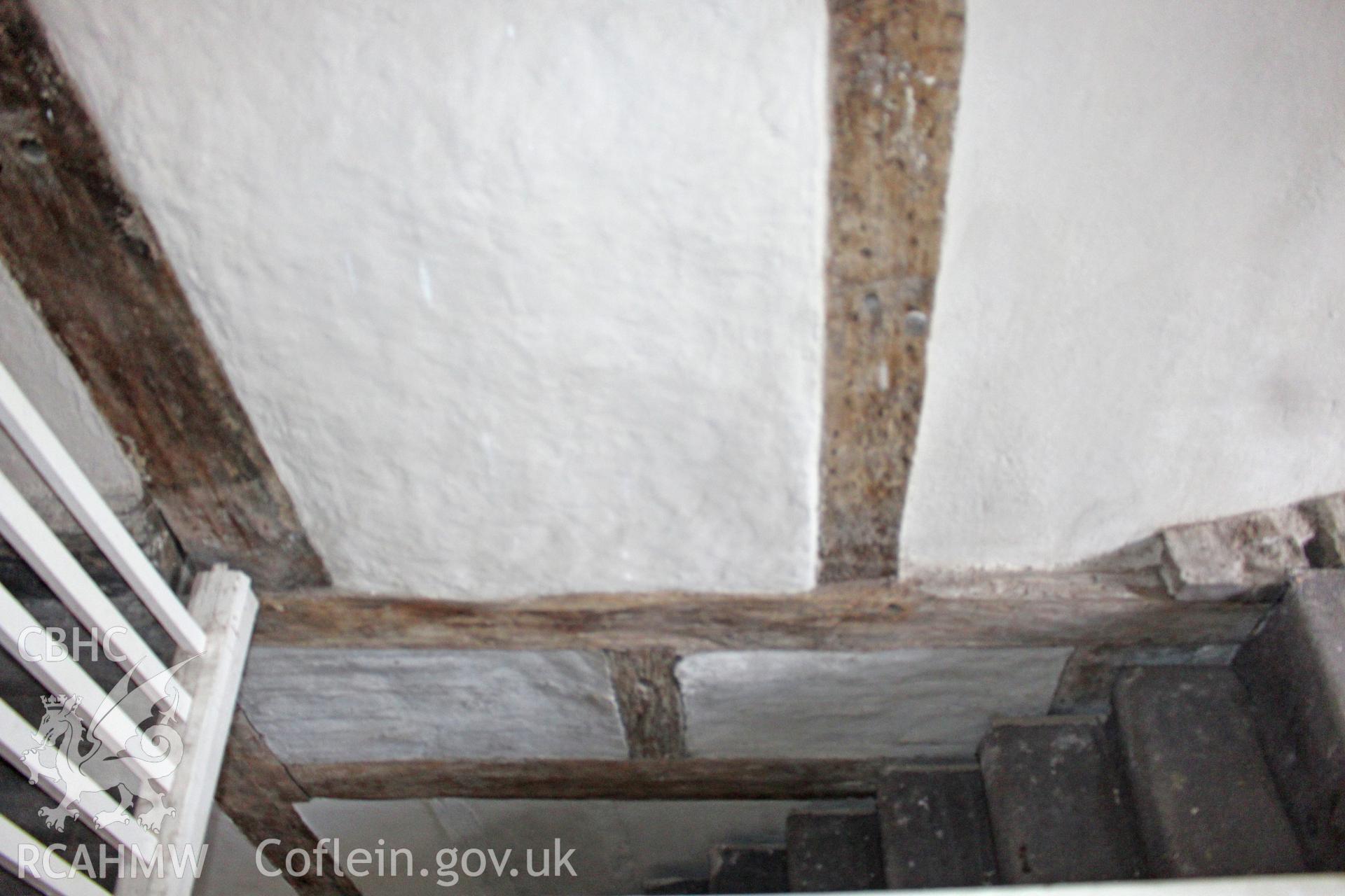 Colour photograph showing interior view of plastered wall, timber frame and staircase at Porth y Dwr, Clwyd Street, Ruthin. Photograph taken during survey conducted by Geoff Ward on 9th October 2014.