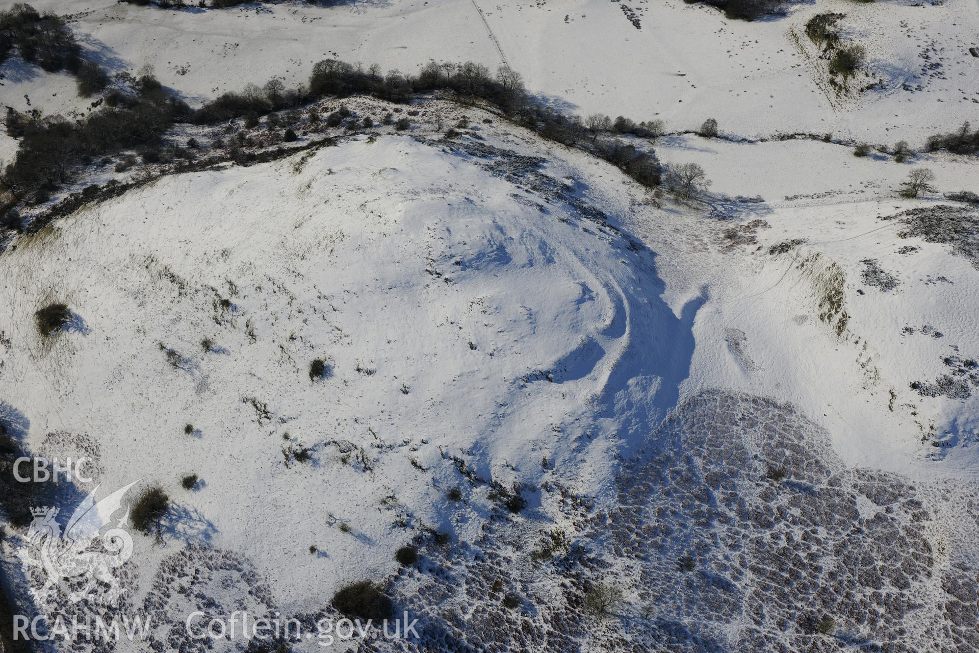 Caer Einon hillfort and three hut platforms, north east of Builth Wells. Oblique aerial photograph taken during the Royal Commission?s programme of archaeological aerial reconnaissance by Toby Driver on 15th January 2013.