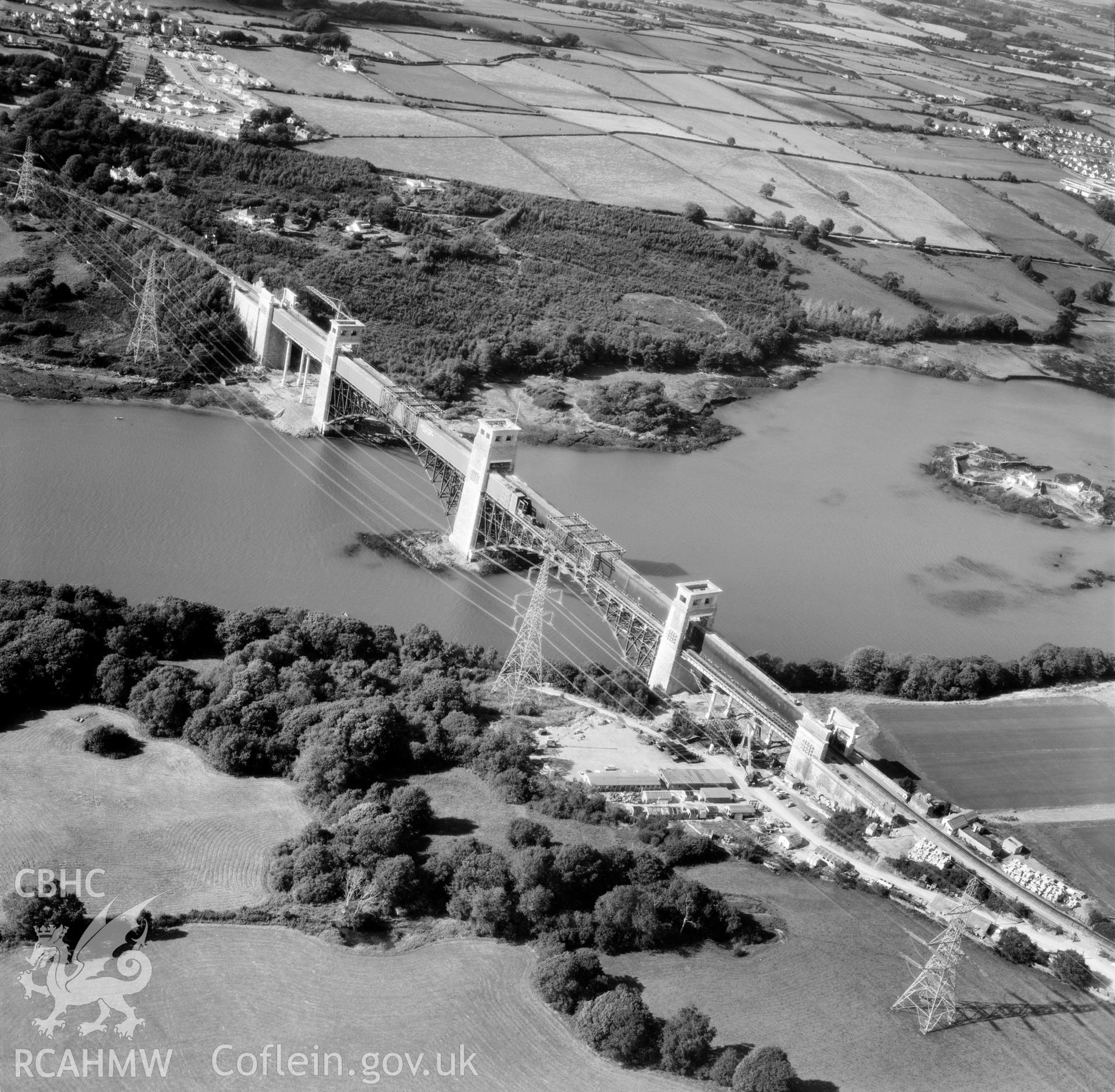 Black and white oblique aerial photograph showing Pont Britannia during its conversion to a dual-purpose road and rail bridge, from Aerofilms album Anglesey, taken by Aerofilms Ltd and dated 10 August 1972.