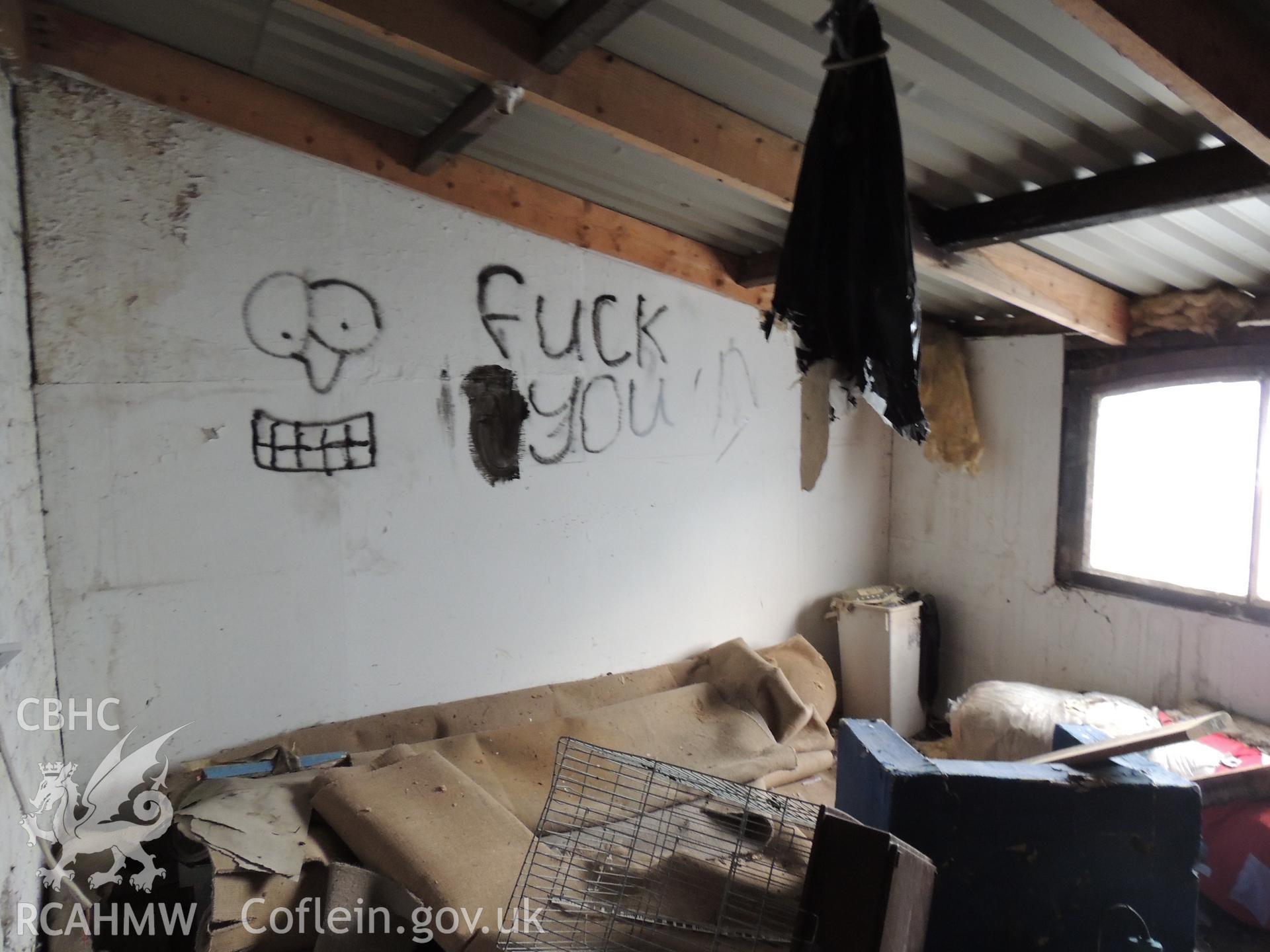 View of graffiti in the south western lean-to, looking south east. Photographed as part of archaeological building survey of The Old Sawmill, Llanidloes, Powys, conducted by Archaeology Wales, 2018. Project no. 2583. Report no. 1645.
