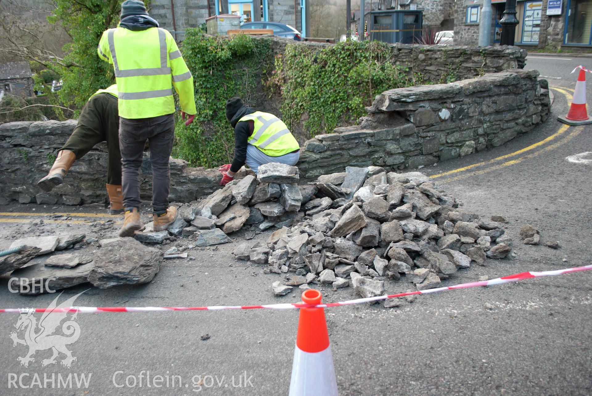 General view during wall demolition showing the hard mortar (in a pile) viewed from the west. Digital photograph taken for Archaeological Watching Brief at Pont y Pair, Betws y Coed, 2019. Gwynedd Archaeological Trust Project no. G2587.
