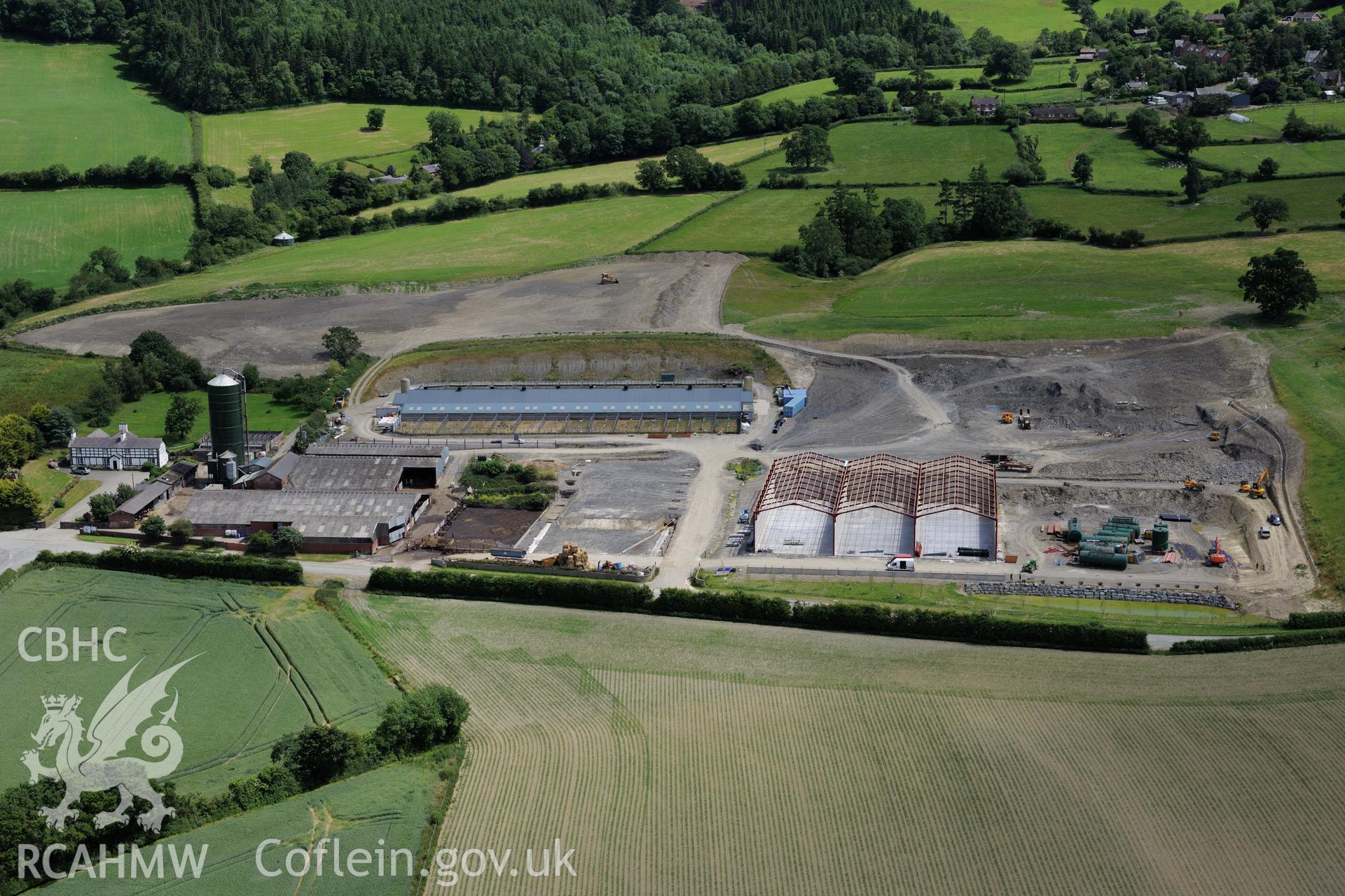 Lower Leighton farmhouse and the new 'super dairy' under construction at Lower Leighton Farm, Leighton, Welshpool. Oblique aerial photograph taken during the Royal Commission's programme of archaeological aerial reconnaissance by Toby Driver on 30th June 2015.