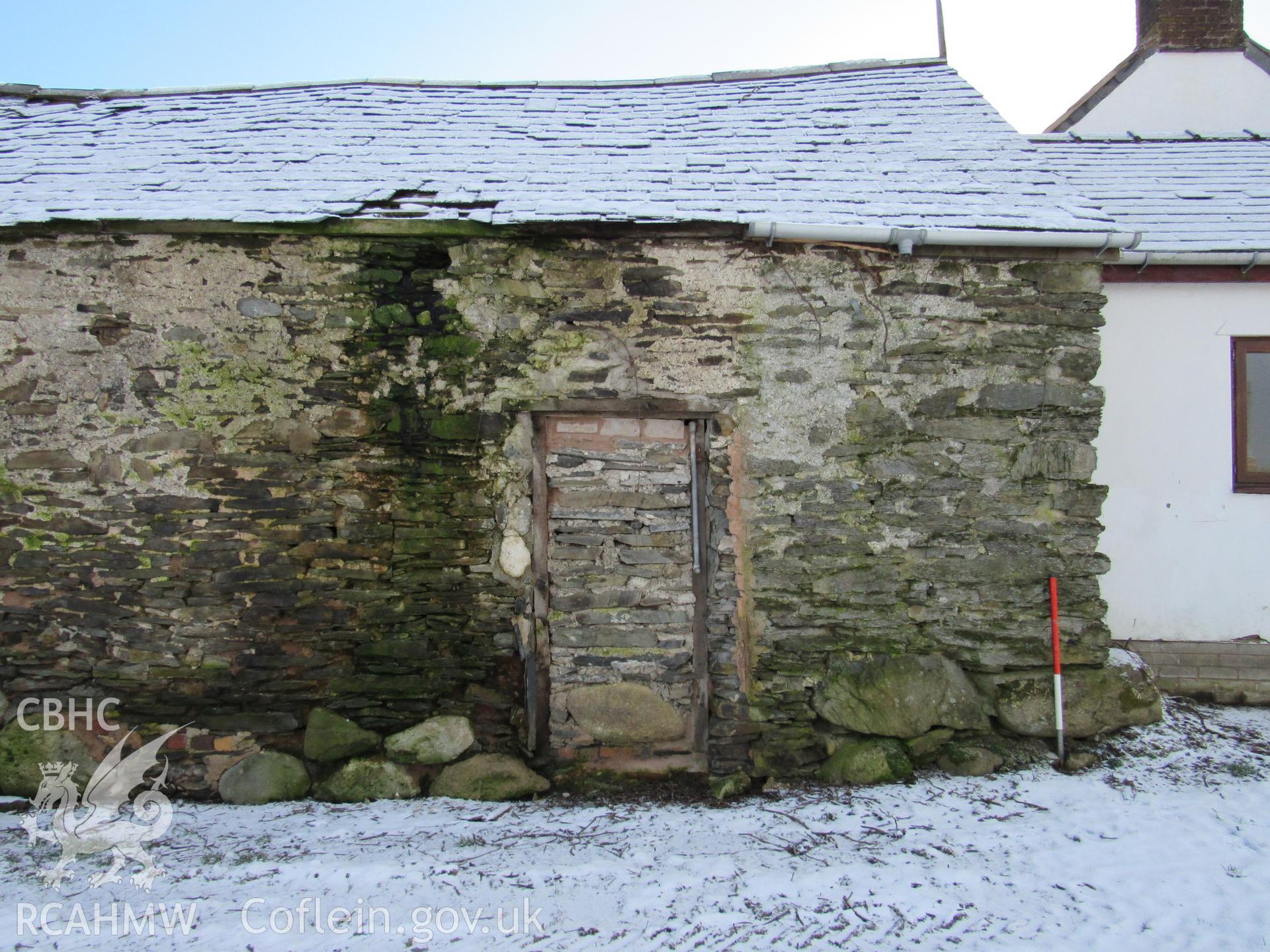 The barn north-west elevation blocked doorway, view south-east. 1m scale. Photographed as part of archaeological building recording conducted at Bryn Ysguboriau, Llanelidan, Denbighshire, carried out by Archaeology Wales, 2018. Project no. P2587.