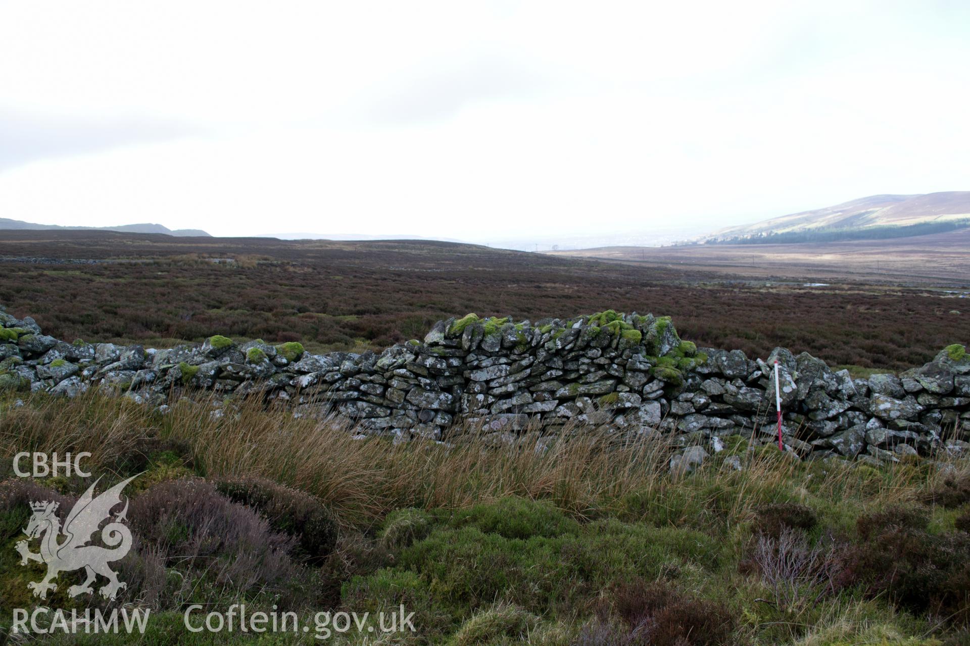 View from the west north west 'of drystone wall at south east end of bulbous linear feature 04.' Photographed by Gwynedd Archaeological Trust as part of walkover survey of Penrhyn Quarry, Bethesda, on 20th February 2018. Project no. G2556.