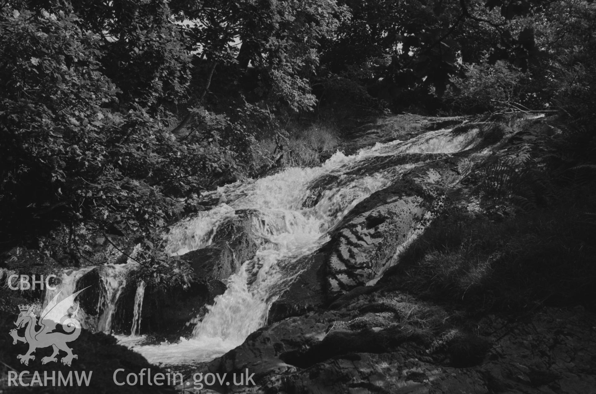 Digital copy of a black and white negative showing waterfall on the Afon Fflur, from the weir at the top of which the mill stream to Felin Fflur starts. Photographed by Arthur O. Chater in August 1967. (Looking east from Grid Reference SN 7213 6426).