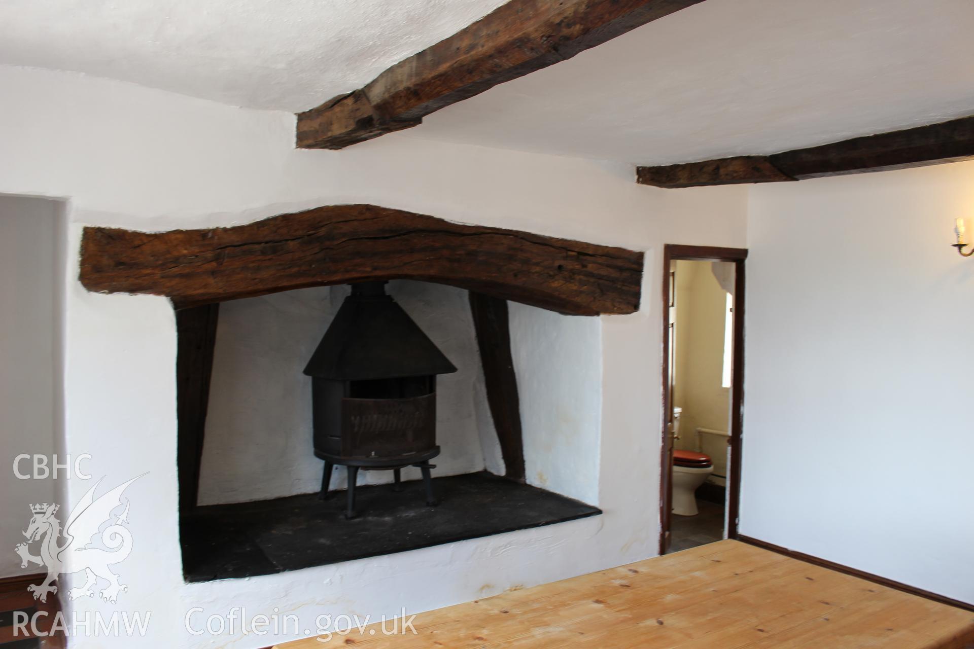 Colour photograph showing detail of woodburning stove in altered fireplace with wooden beam above at 5-7 Mwrog Street, Ruthin. Photographed during survey conducted by Geoff Ward on 14th May 2014.