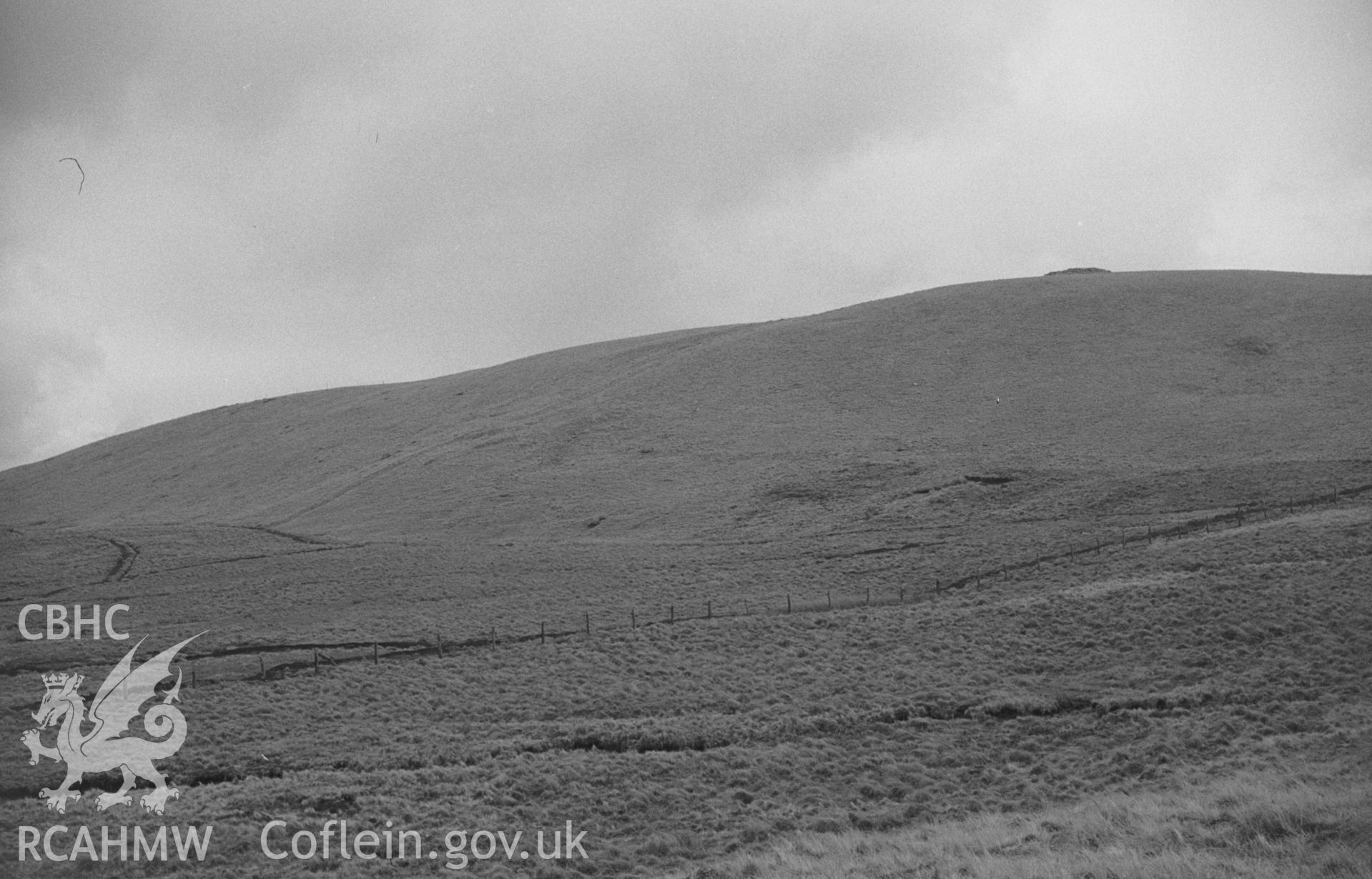 Digital copy of black and white negative showing westerly 1762ft cairn on skyline on right, ditch and bank of Gwys-yr-Ychen-Bannog running down slope to left. Photographed by Arthur O. Chater in April 1966 looking east north east from Grid Ref SN 734 611.