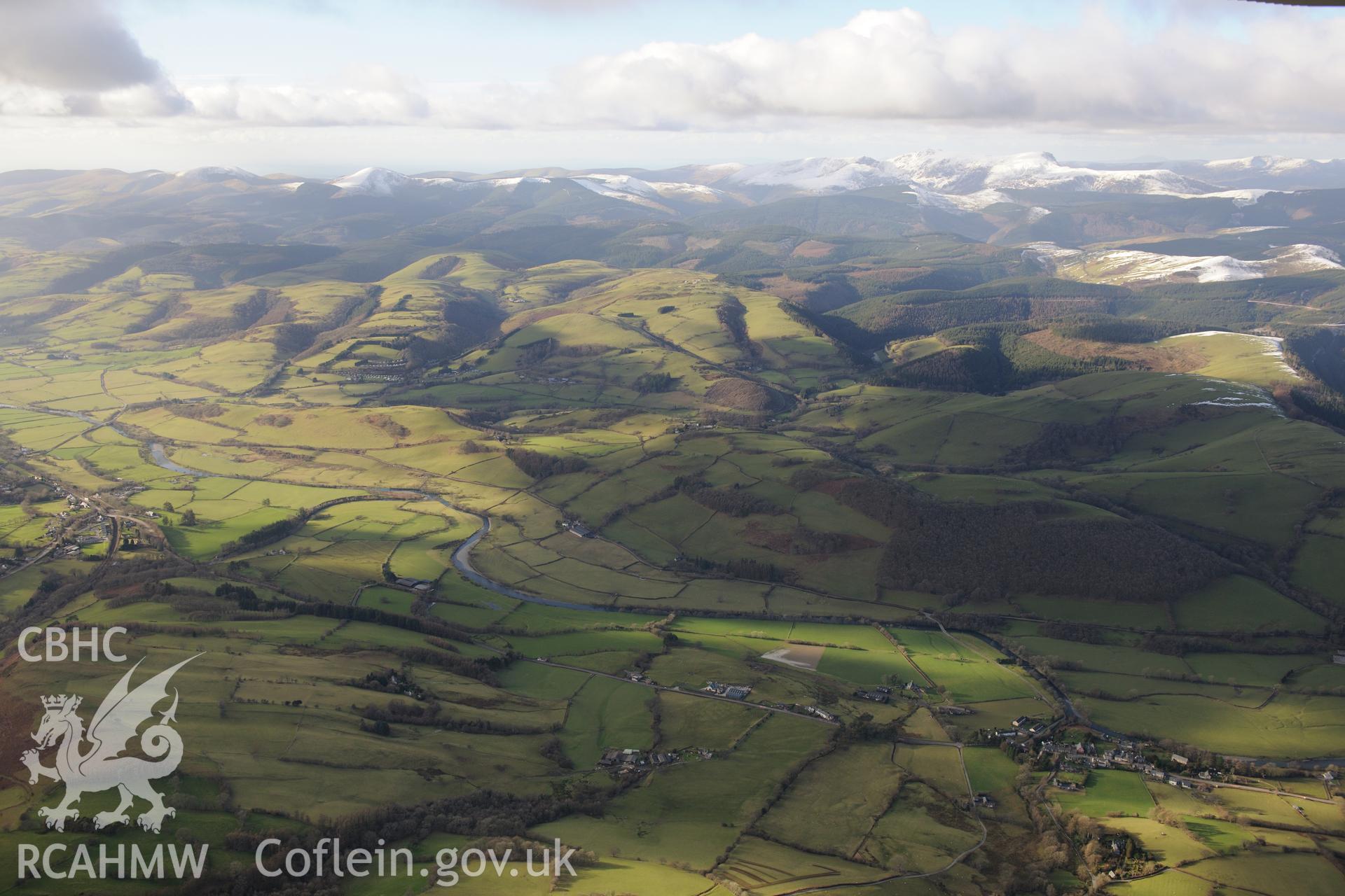 View of the Dyfi valley taken from the south east, with Glantwymyn to the left, Cemmaes to the right and the snow-capped hills surrounding Cadair Idris beyond. Oblique aerial photograph taken during the Royal Commission's programme of archaeological aerial reconnaissance by Toby Driver on 4th February 2015.