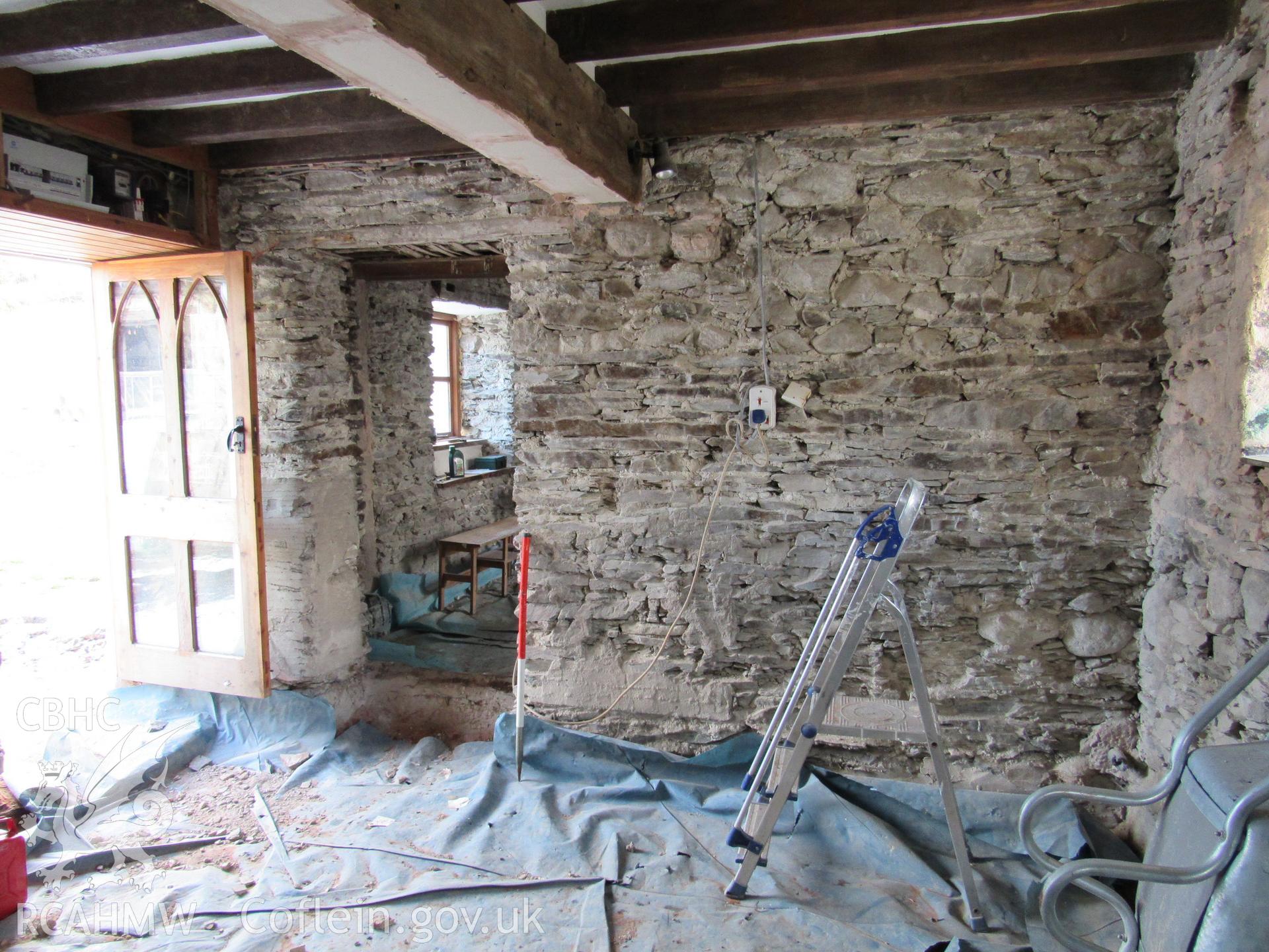 Kitchen in original house with doorway to lounge, view south-east. 1m scale. Photographed as part of archaeological building recording conducted at Bryn Ysguboriau, Llanelidan, Denbighshire, carried out by Archaeology Wales, 2018. Project no. P2587.