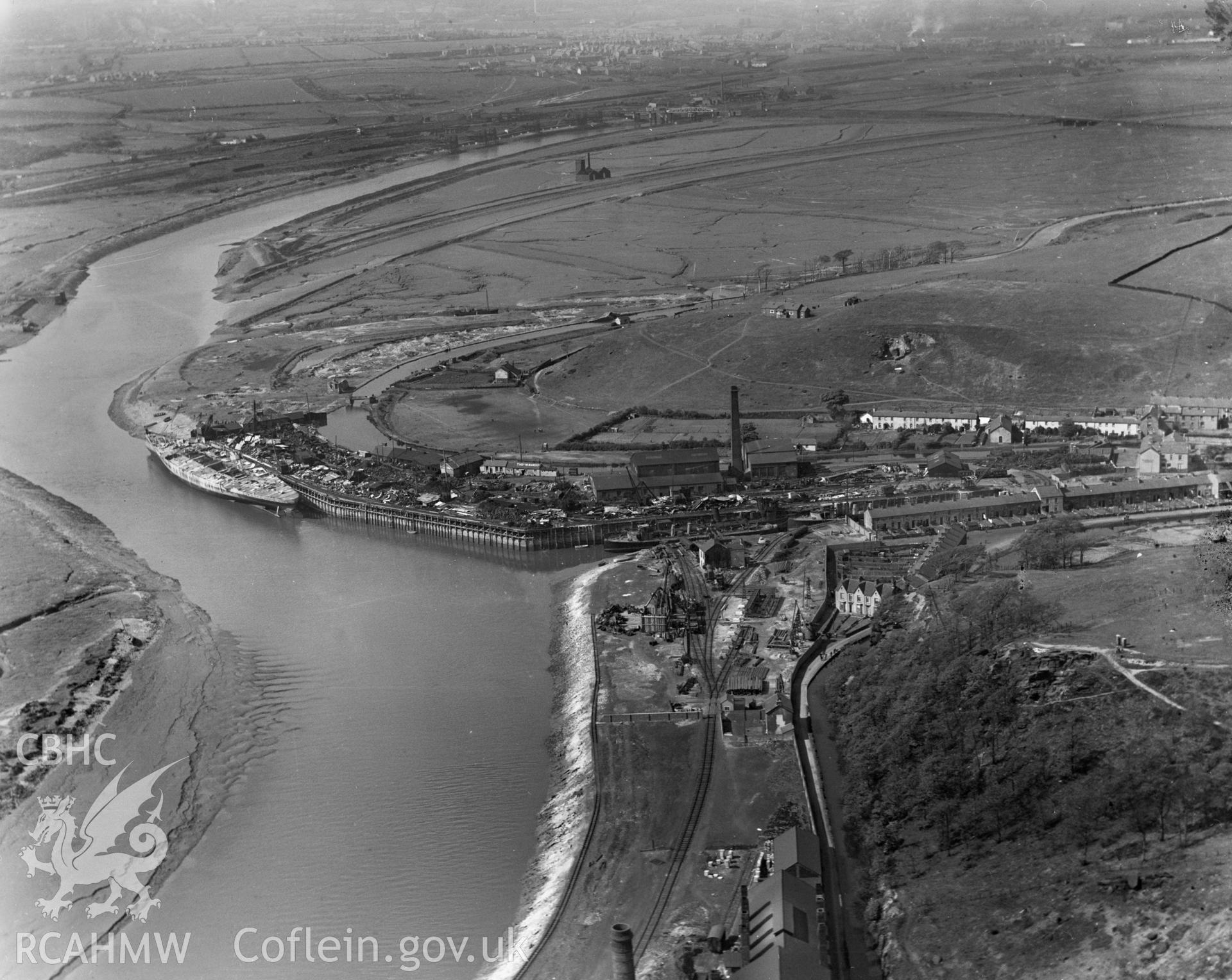 View of Briton Ferry dock showing naval vessel in process of being scrapped, oblique aerial view. 5?x4? black and white glass plate negative.