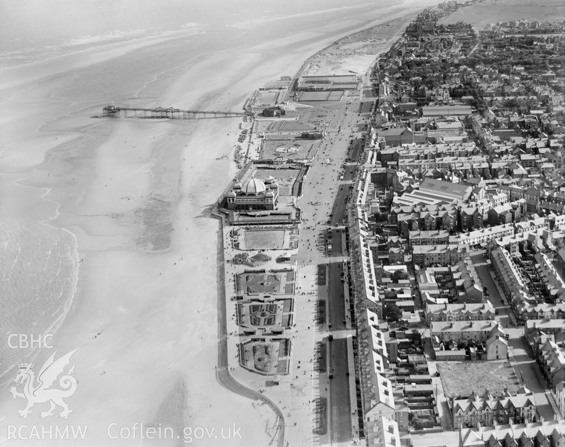 View of Rhyl showing promenade, pier, bandstand, pleasure gardens and open air swimming pool, oblique aerial view. 5?x4? black and white glass plate negative.