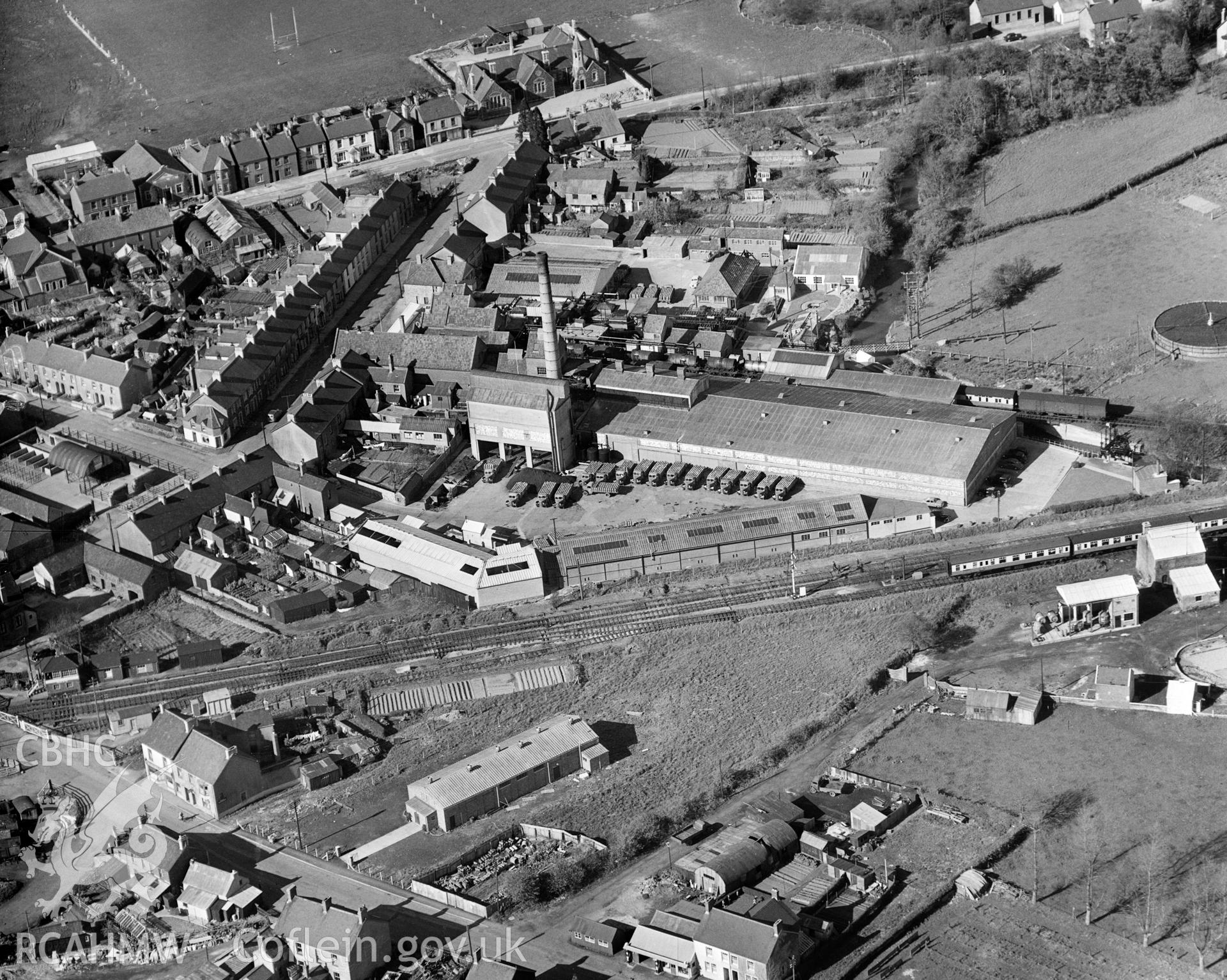 Digital copy of a black and white, oblique aerial photograph of Whitland Creamery. The photograph shows the view from the South West. The creamery was established in 1914 and grew to become the largest manufacturing creamery in Britain, covering an area of nearly eight hectares. It closed in November 1994 and the site has been cleared for redevelopment. Photograph taken by Aero Pictorial Ltd.