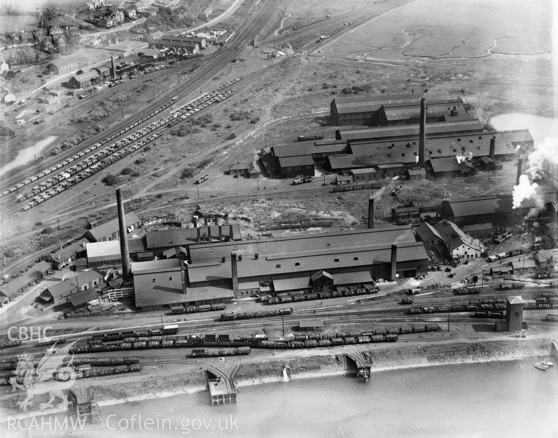 View of Baglan Bay Tinplate Co., Briton Ferry, with Whitford works in background. From the northwest. Oblique aerial view. 5?x4? black and white glass plate negative.