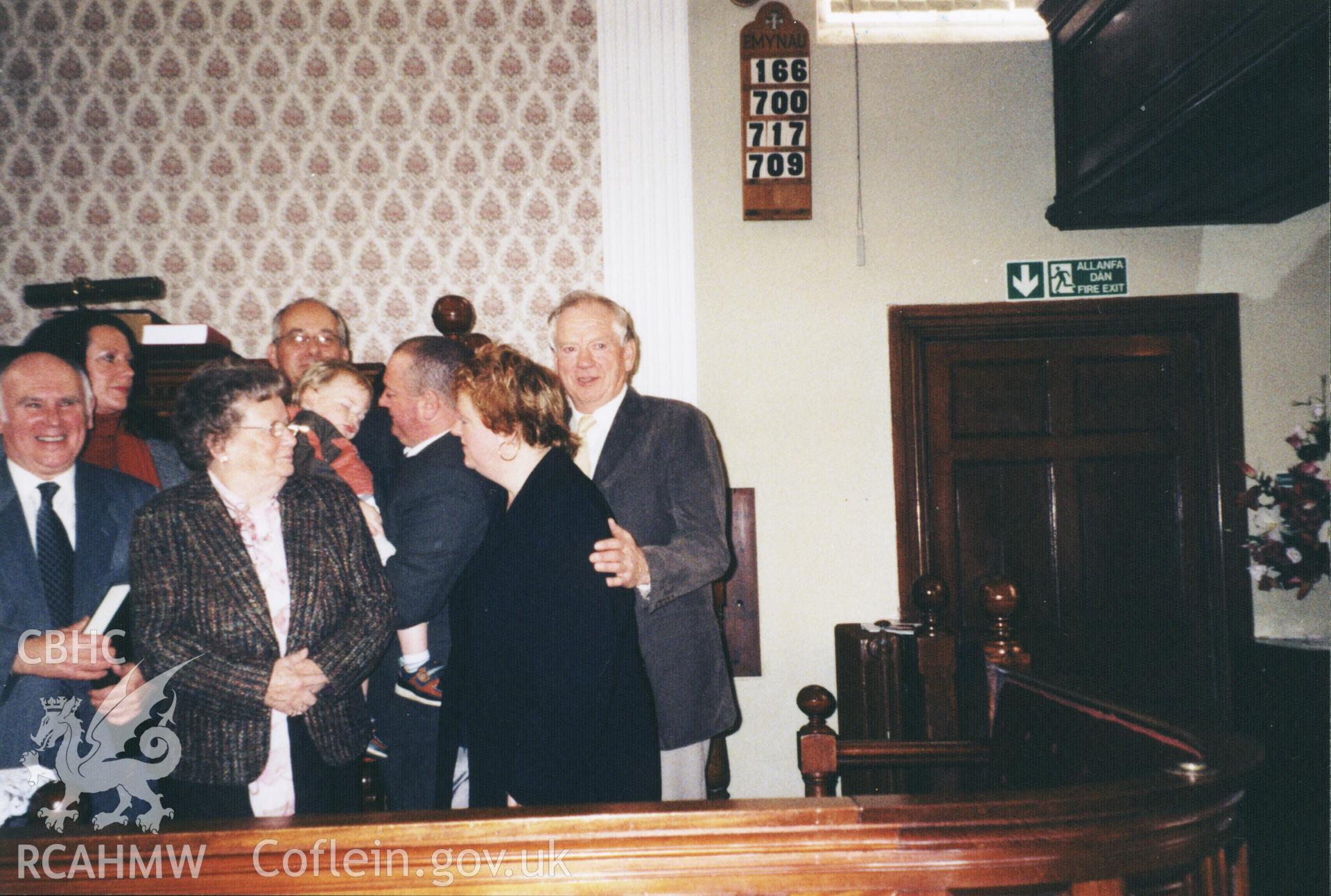 Colour photograph of Gareth Edwards (left), Nesta Williams and Robin Jones during christening, December 2006. Donated as part of the Digital Dissent Project.