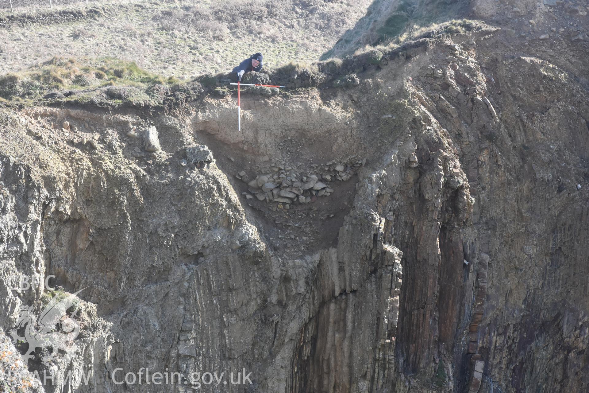 Porth y Rhaw promontory fort. Photograph of eroded section through western rock-cut ditch. ? Crown: CHERISH PROJECT 2017. Produced with EU funds through the Ireland Wales Co-operation Programme 2014-2020. All material made freely available through the Open Government Licence.