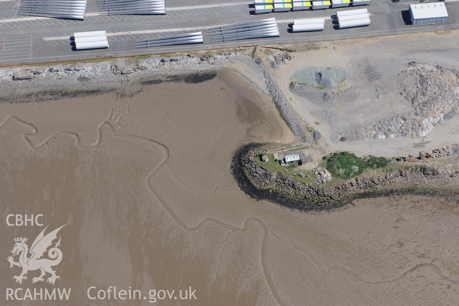 Mostyn Quay in the port of Mostyn, with windfarm parts, and Pill Box I, Whitford. Oblique aerial photograph taken during the Royal Commission?s programme of archaeological aerial reconnaissance by Toby Driver on 22nd May 2013.