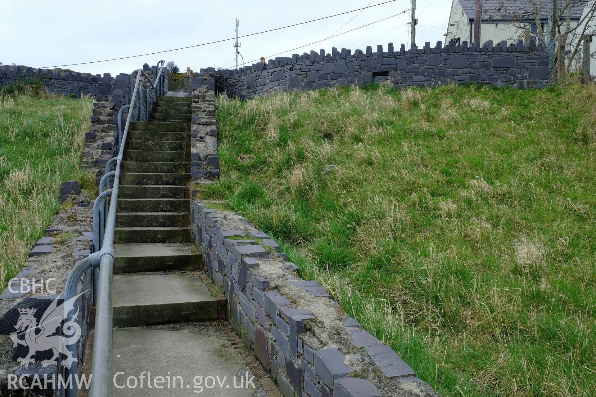 Colour photograph showing view looking north at modern slate walls near the steps from Water Street to Carneddi Road, Bethesda, produced by Richard Hayman 16th March 2017
