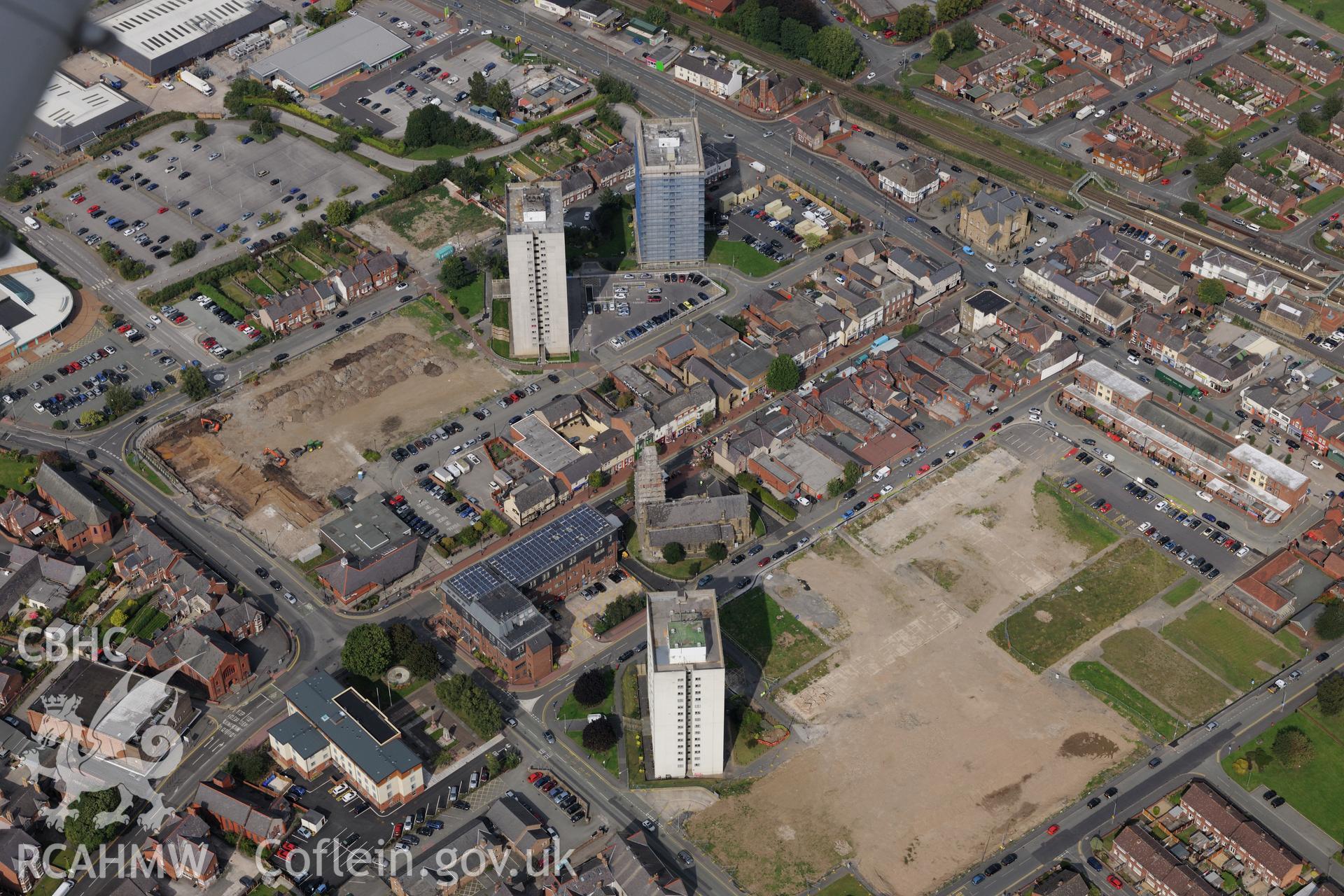 St. Mary's church and Flinshire Retail Centre on site of demolished housing estate, Flint. Oblique aerial photograph taken during the Royal Commission's programme of archaeological aerial reconnaissance by Toby Driver on 11th September 2015.