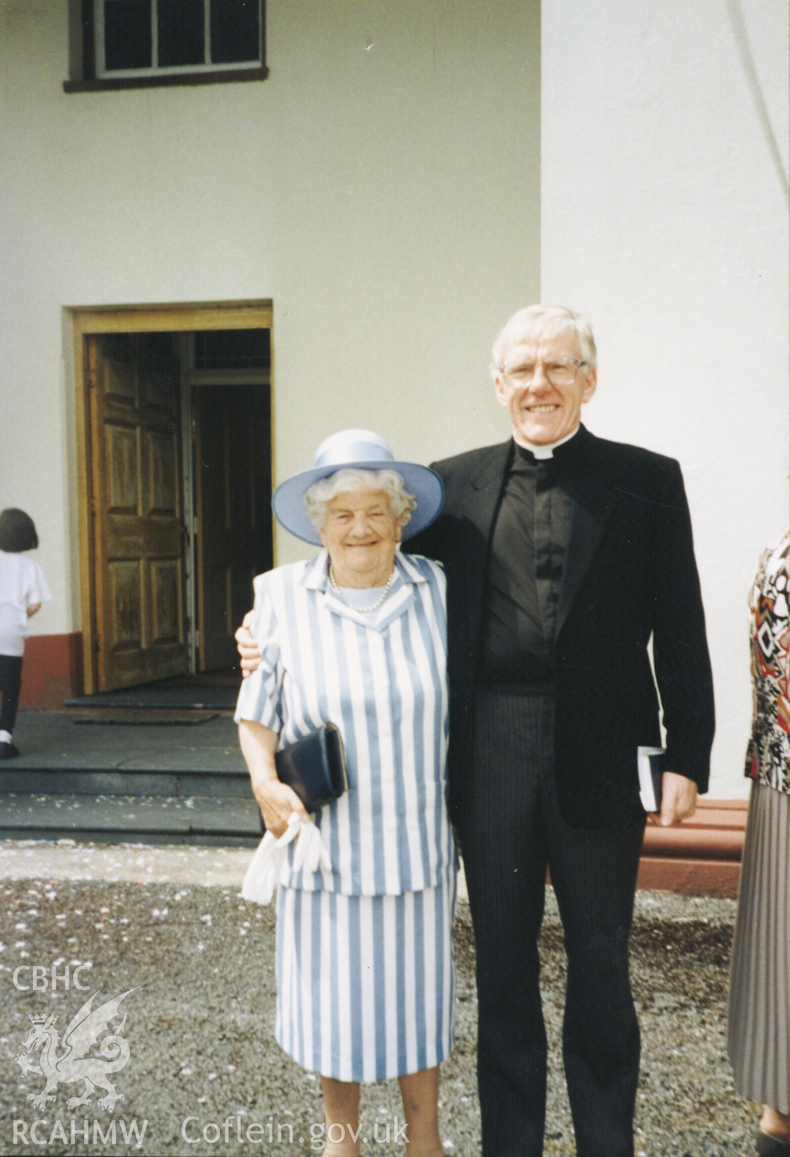 Colour photograph of Minister R. E. Hughes (ordained in 1989) and Miss Lena Jones in front of Peniel Chapel during a wedding. Catherine Jones in middle. Donated as part of the Digital Dissent Project.