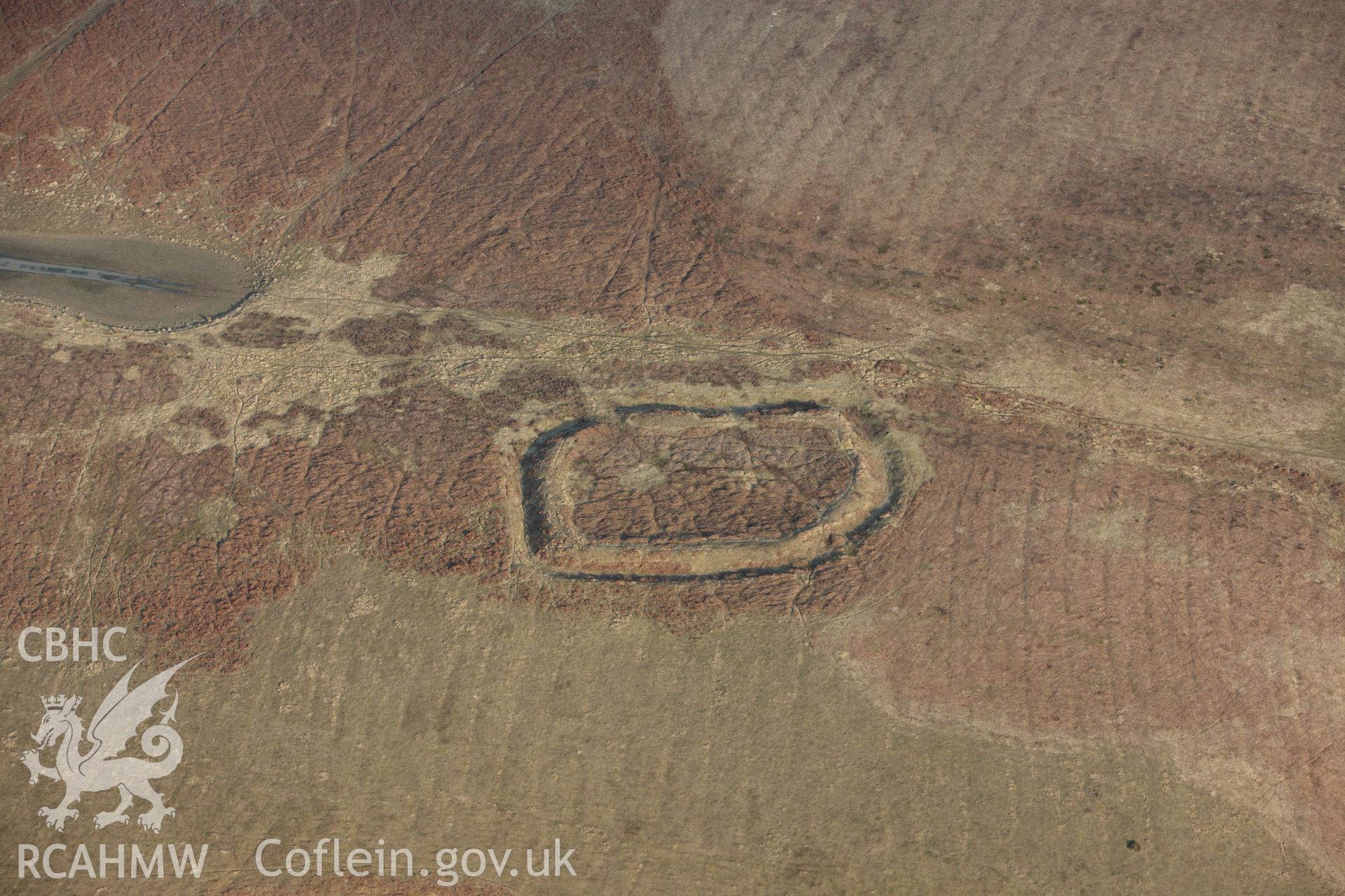 RCAHMW colour oblique photograph of Coed Swydd Enclosure. Taken by Toby Driver on 11/03/2010.