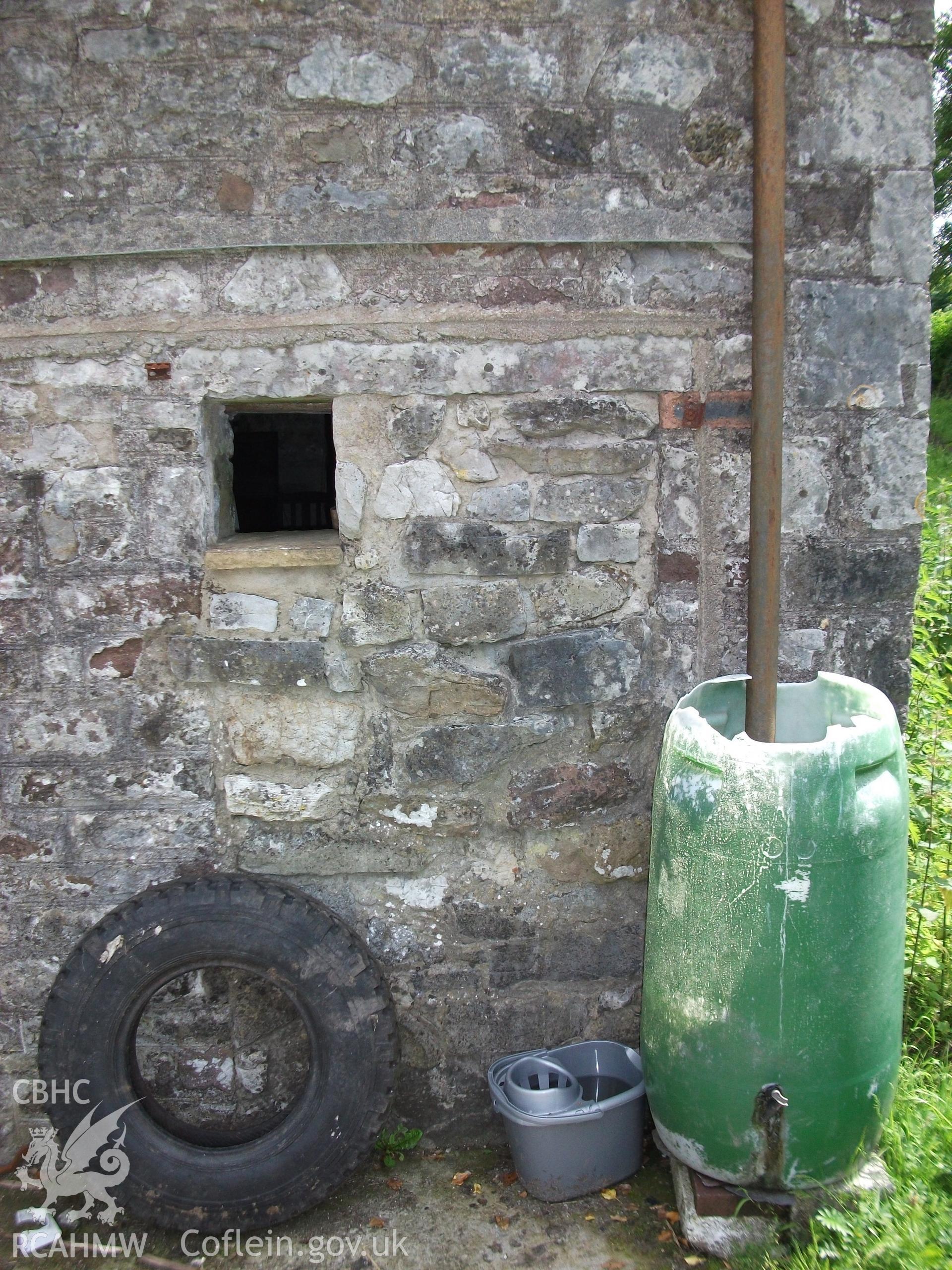 Photograph showing detailed view of the exterior front elevation and water butt of 'ale and pail barn,' at Pant-y-Castell, Maesybont, Photographed by Mark Waghorn to meet a condition attached to planning application.
