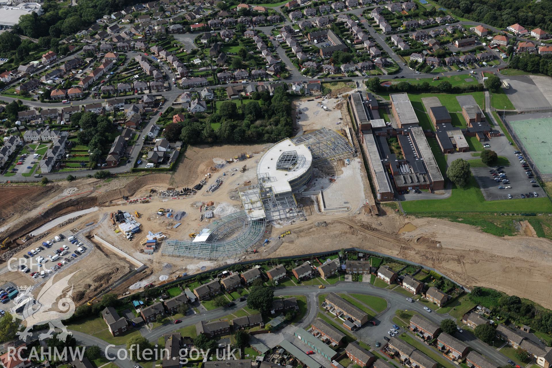 Holywell High School, with Ysgol Treffynon and Ysgol Maes y Felin under construction behind. Oblique aerial photograph taken during the Royal Commission's programme of archaeological aerial reconnaissance by Toby Driver on 11th September 2015.
