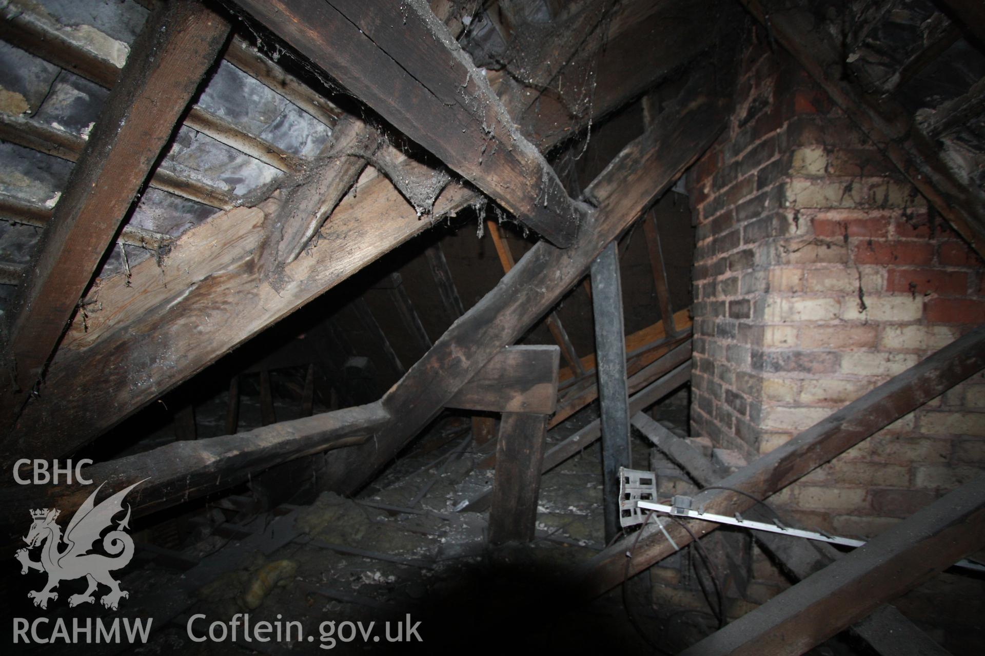 Colour photograph showing interior of timber roof frame and brick chimney stack at Porth-y-Dwr, 67 Clwyd Street, Ruthin. Photographed during survey conducted by Geoff Ward on 10th June 2013.