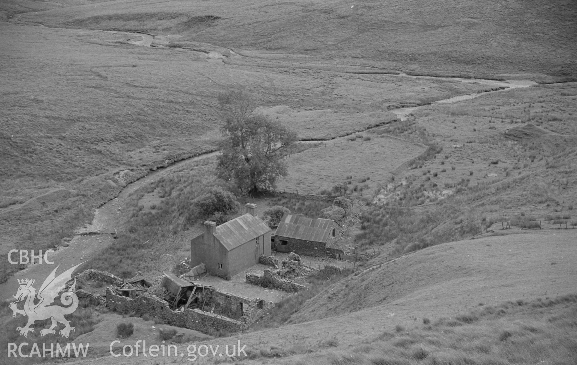 Digital copy of a black and white negative showing Moel Prysgau farmstead, on the banks of the river Tywi. Photographed by Arthur O. Chater in August 1965 looking downstream (south east) from the new forestry road at Grid Reference SN 8053 6124.